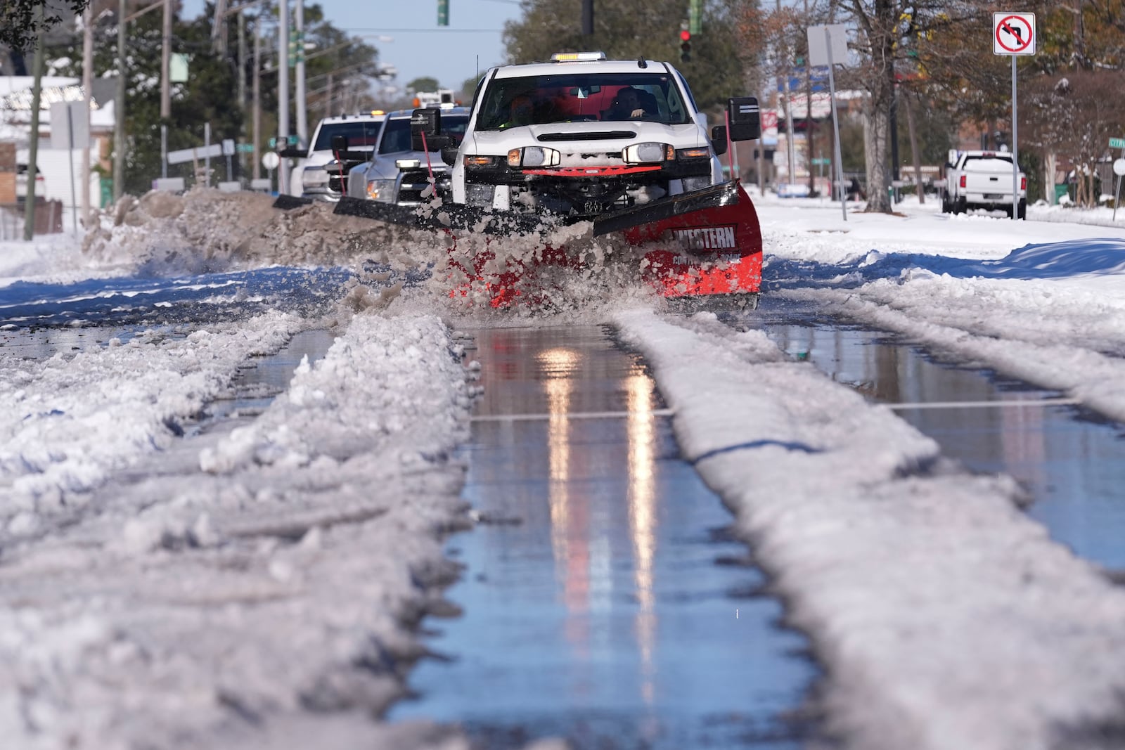 Snowplows clear snow from Jefferson Highway the day after a rare and record setting snowstorm in River Ridge, La., a suburb of New Orleans, Wednesday, Jan. 22, 2025. (AP Photo/Gerald Herbert)