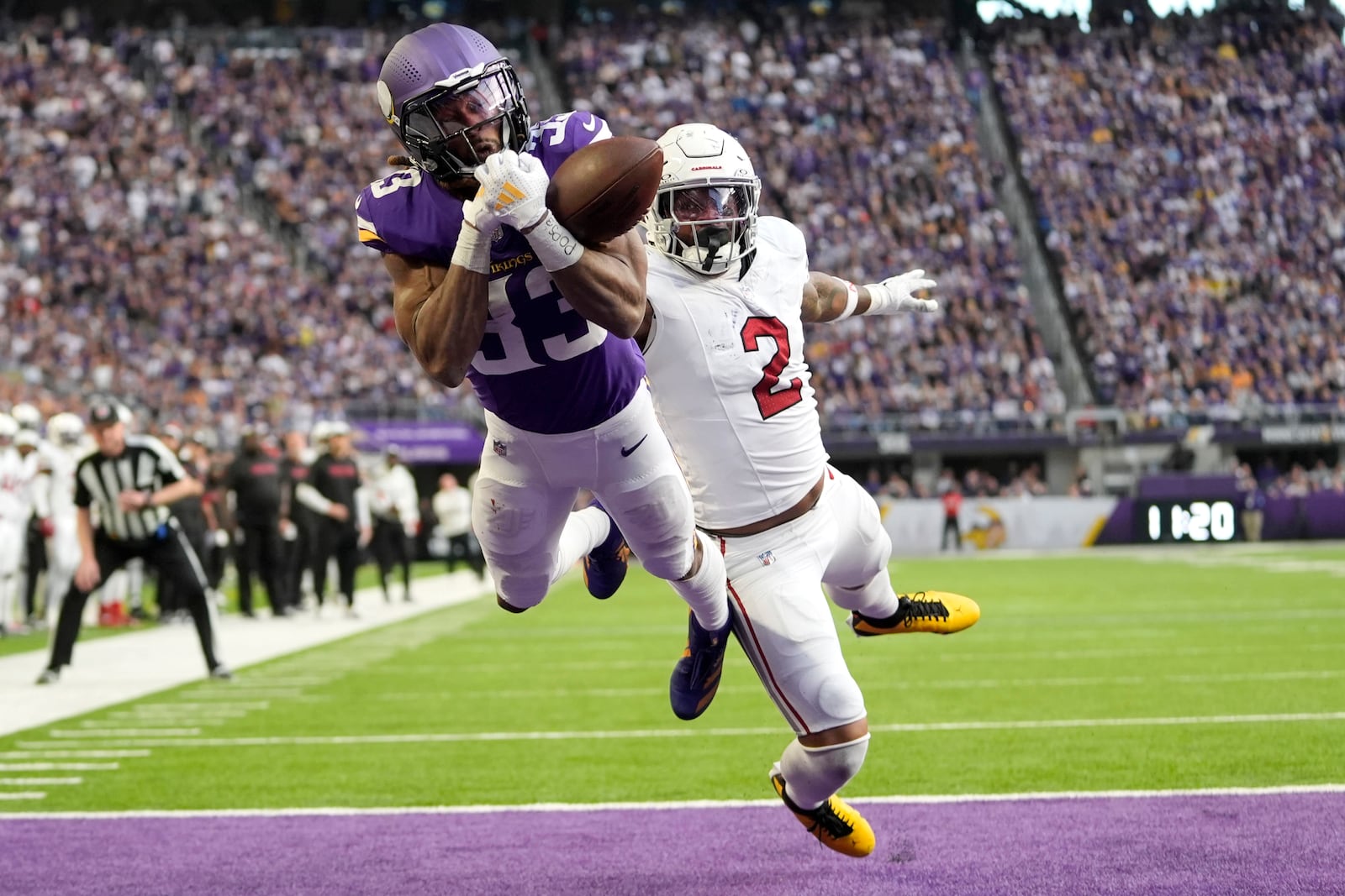 Minnesota Vikings running back Aaron Jones (33) reaches for an incomplete pass ahead of Arizona Cardinals linebacker Mack Wilson Sr. (2) during the second half of an NFL football game Sunday, Dec. 1, 2024, in Minneapolis. (AP Photo/Abbie Parr)