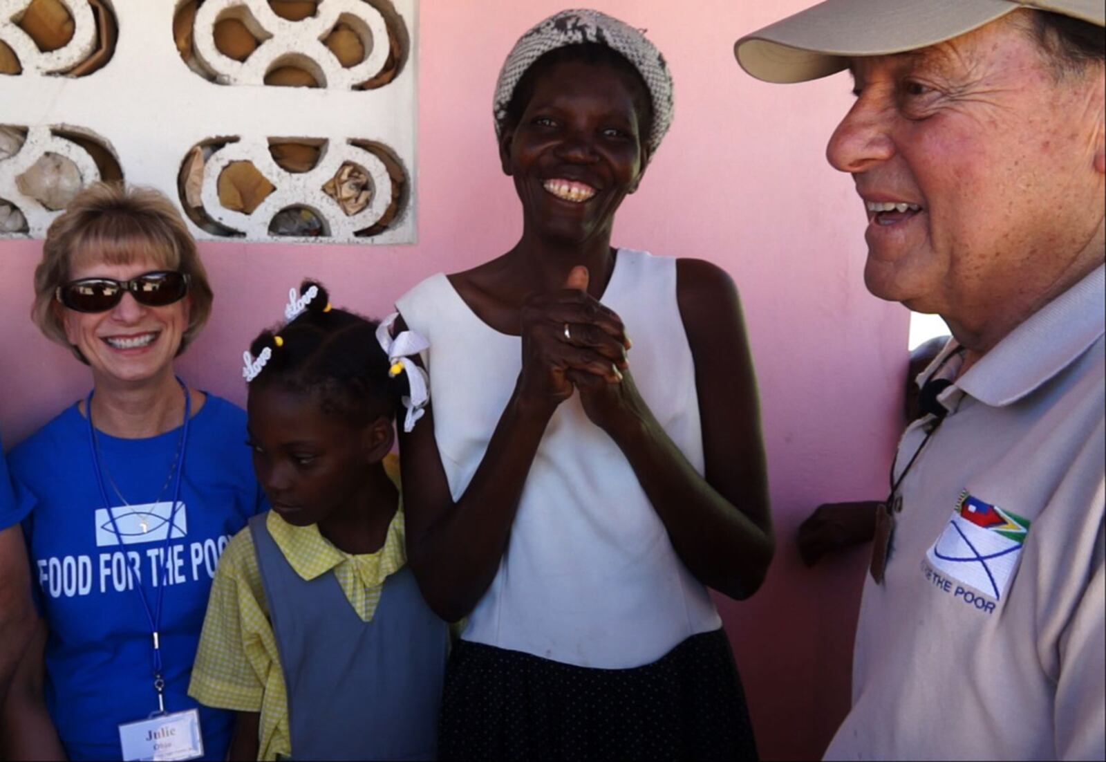 Marie is all smiles as she welcomes Hope For Haitians Co-Chairman Ben Scott of Piqua and Scott's family friend Julie Gilardi, also of Piqua, to her new home in Savann Kabrit, Haiti. (Photo/Food For The Poor)