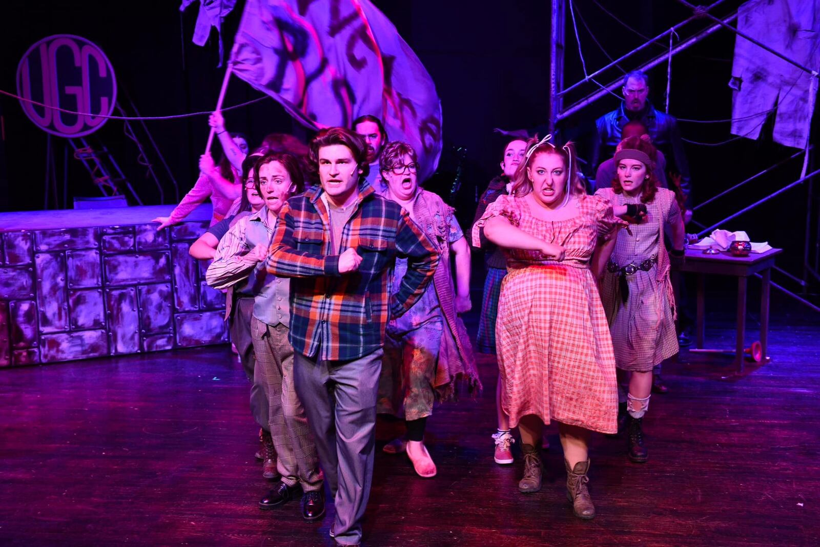 Garrett Young (center as Bobby Strong) and the cast of TheatreLab Dayton's production of "Urinetown." PHOTO BY MACKENSIE KING