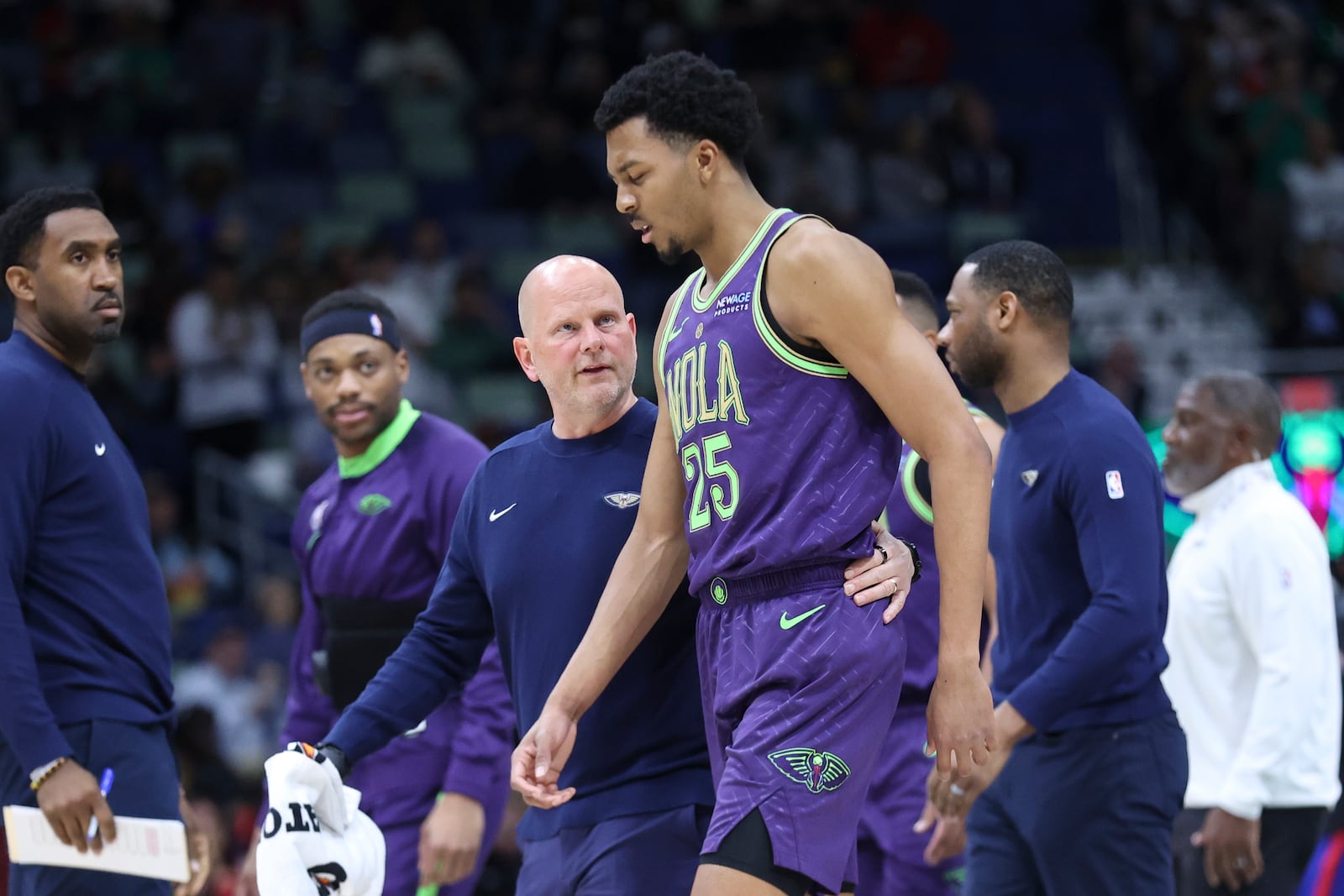 A member of the New Orleans Pelicans staff walks New Orleans Pelicans guard Trey Murphy III (25) off the court after an injury in the first half of an NBA basketball game against the Detroit Pistons in New Orleans, Monday, March 17, 2025. (AP Photo/Peter Forest)