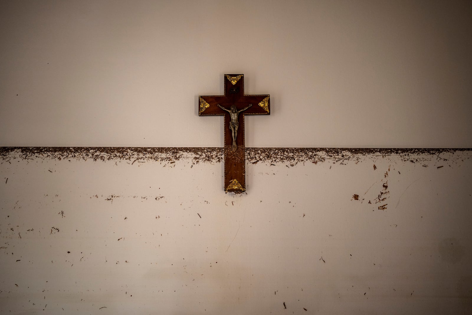 A crucifix hangs near the water level marker in an area affected by floods in Paiporta, Valencia, Spain, Tuesday, Nov. 5, 2024. (AP Photo/Emilio Morenatti)