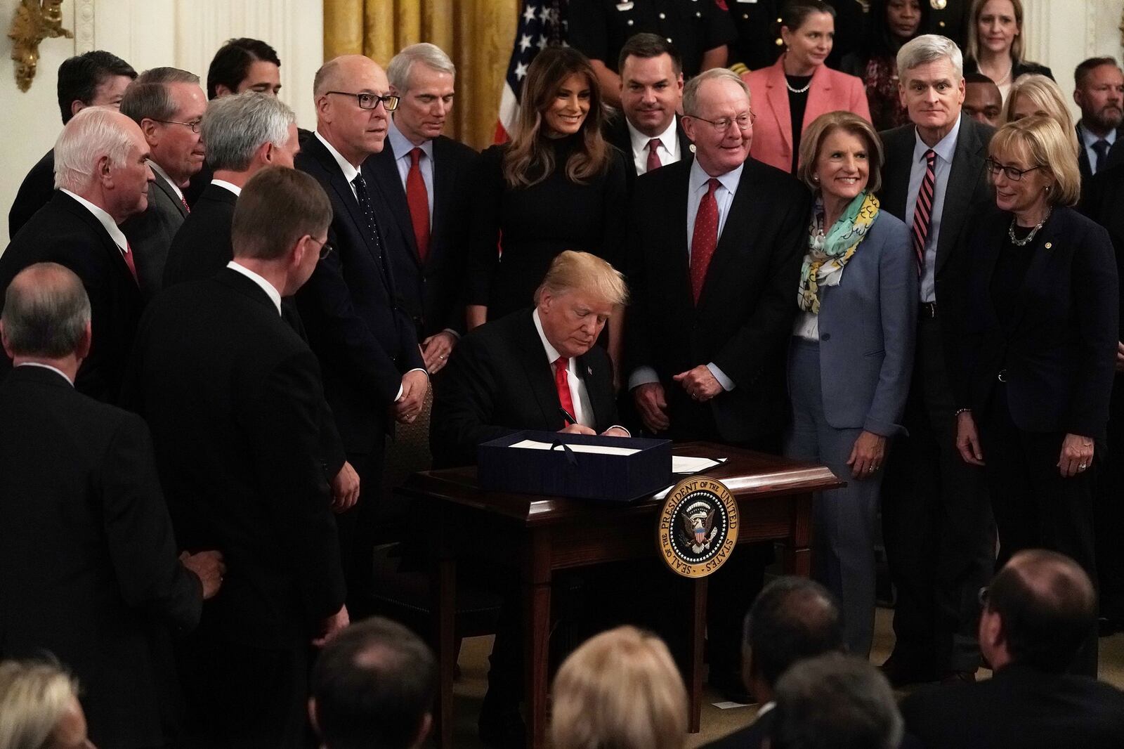 WASHINGTON, DC - OCTOBER 24: Flanked by lawmakers and first lady Melania Trump, U.S. President Donald Trump participates in a bill signing to dedicate more resources to fight the opioid crisis during an East Room event at the White House October 24, 2018 in Washington, DC. President Trump hosted an event to mark the one-year anniversary of the administration’s declaration of combating the opioid crisis. (Photo by Alex Wong/Getty Images)