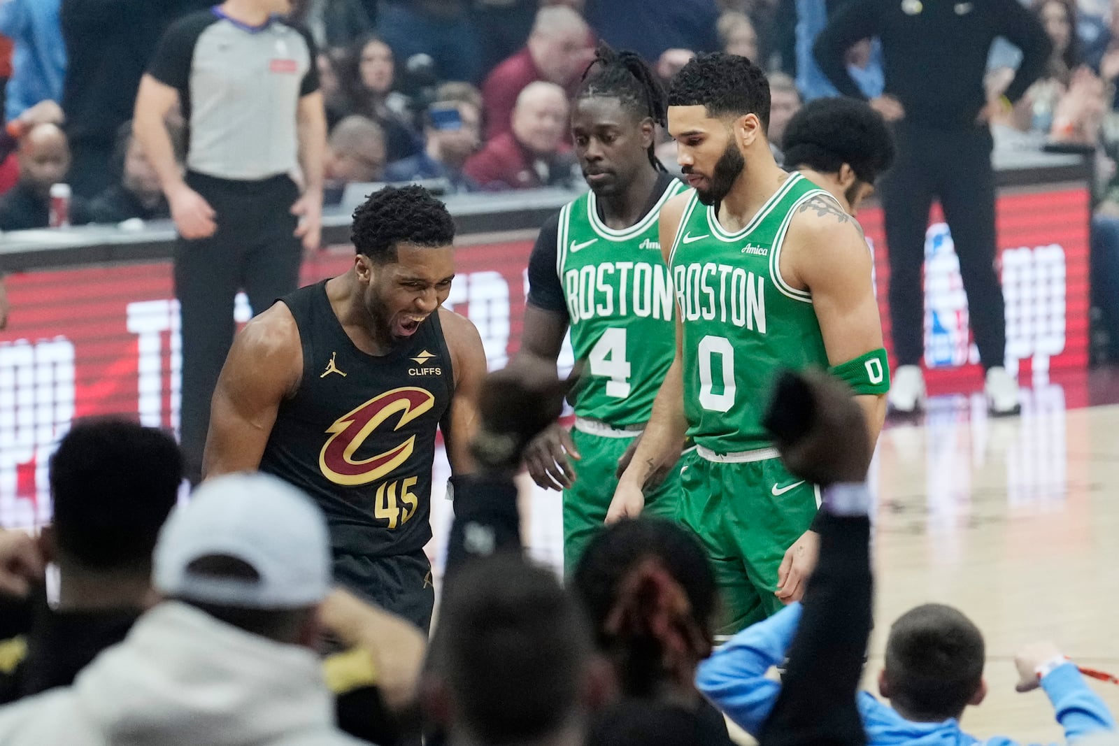 Cleveland Cavaliers guard Donovan Mitchell (45) shouts in front of Boston Celtics guard Jrue Holiday (4) and forward Jayson Tatum (0) after dunking in the first half of an NBA basketball game, Tuesday, Feb. 4, 2025, in Cleveland. (AP Photo/Sue Ogrocki)