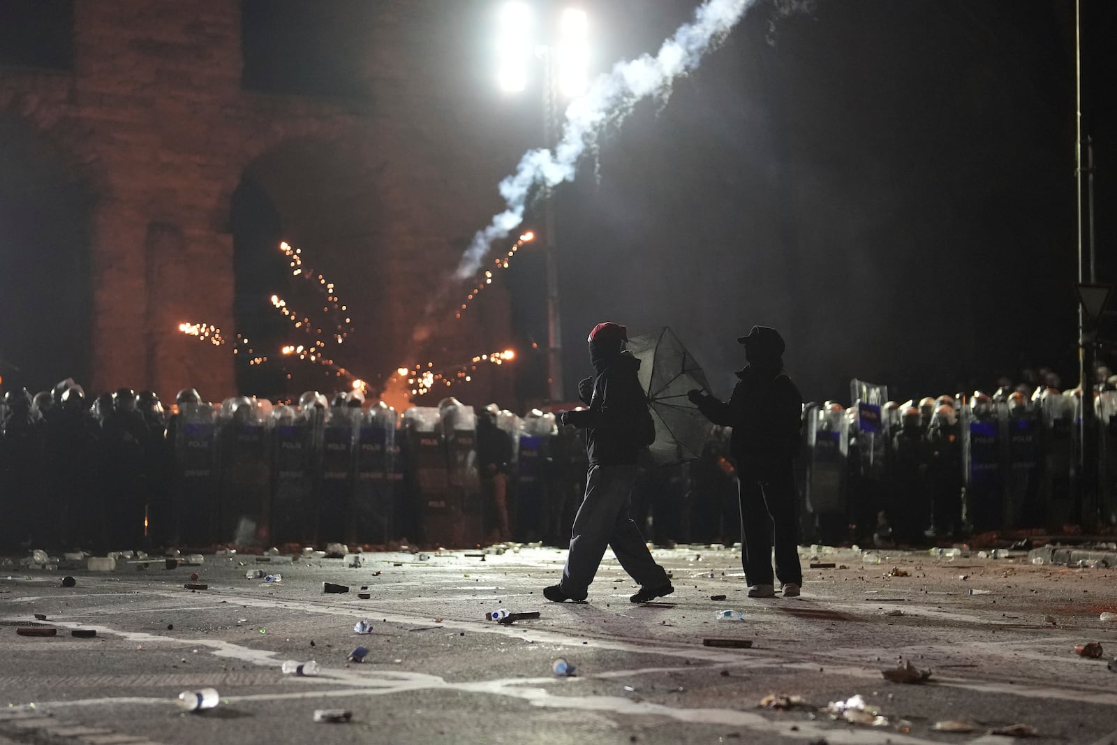 Fireworks thrown by protesters explode over riot police during a protest against the arrest of Istanbul's Mayor Ekrem Imamoglu, in Istanbul, Turkey, Saturday, March 22, 2025. (AP Photo/Khalil Hamra)