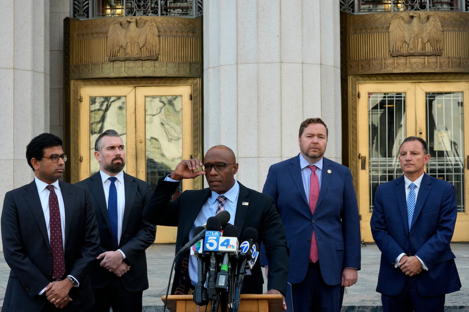 FBI Assistant Director Akil Davis, center joined by Acting U.S. Attorney Joseph T. McNally, second from right and other officials, discuss court filings related to the Palisades Fire investigation outside the U.S. Courthouse in downtown Los Angeles on Friday, Jan. 31, 2025. (AP Photo/Damian Dovarganes)