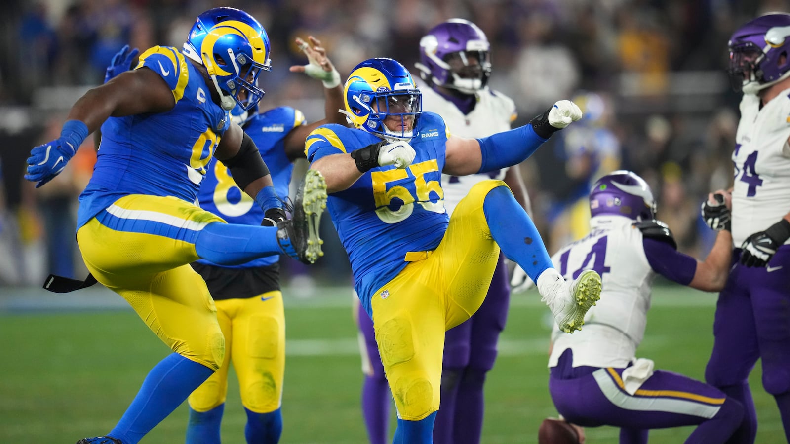 Los Angeles Rams defensive tackle Kobie Turner (91) and Los Angeles Rams defensive tackle Braden Fiske (55) celebrate a sack on Minnesota Vikings quarterback Sam Darnold (14) during the second half of an NFL wild card playoff football game, Monday, Jan. 13, 2025, in Glendale, Ariz. (AP Photo/Ross D. Franklin)