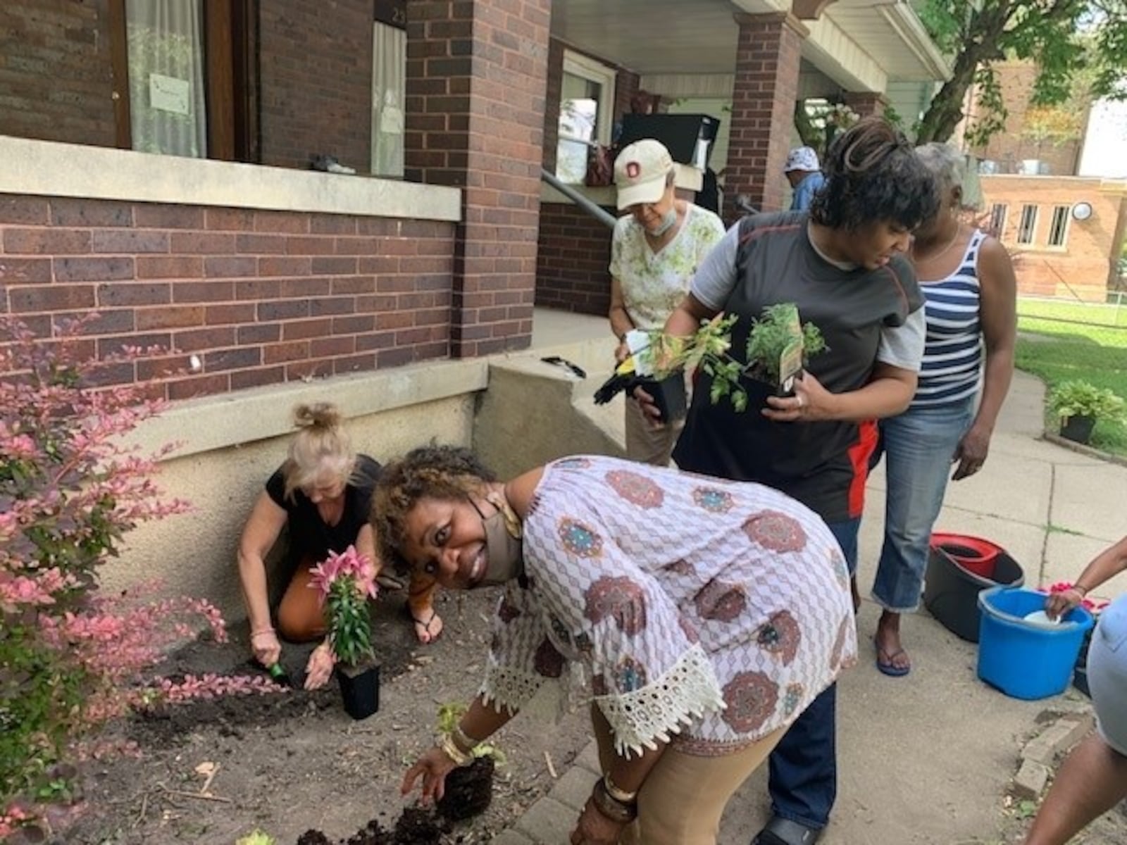 Residents and volunteers plant together at Mercy Manor. CONTRIBUTED