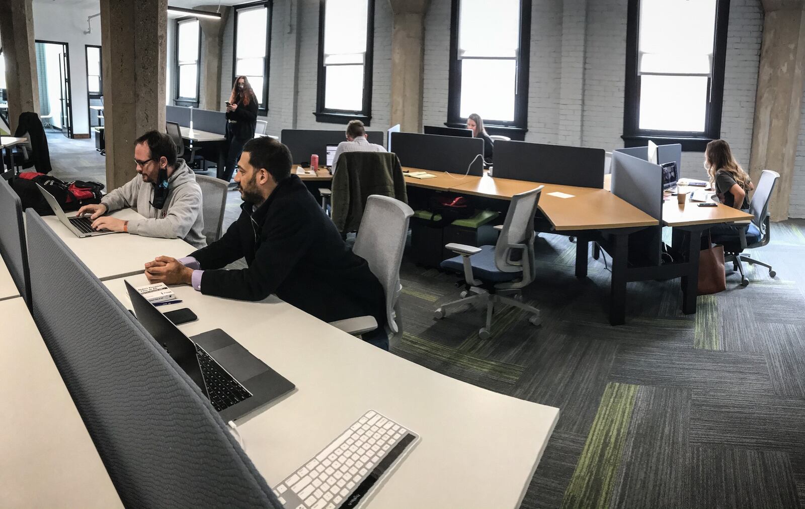 Dayton systems engineering company, Mile Two, is moving into its new offices at 601 E. Third Street. From Left, Michael Heroux and Taj Varani work in the new office, which will continue using a hybrid model of some employees working remote and others in the office.  JIM NOELKER/STAFF