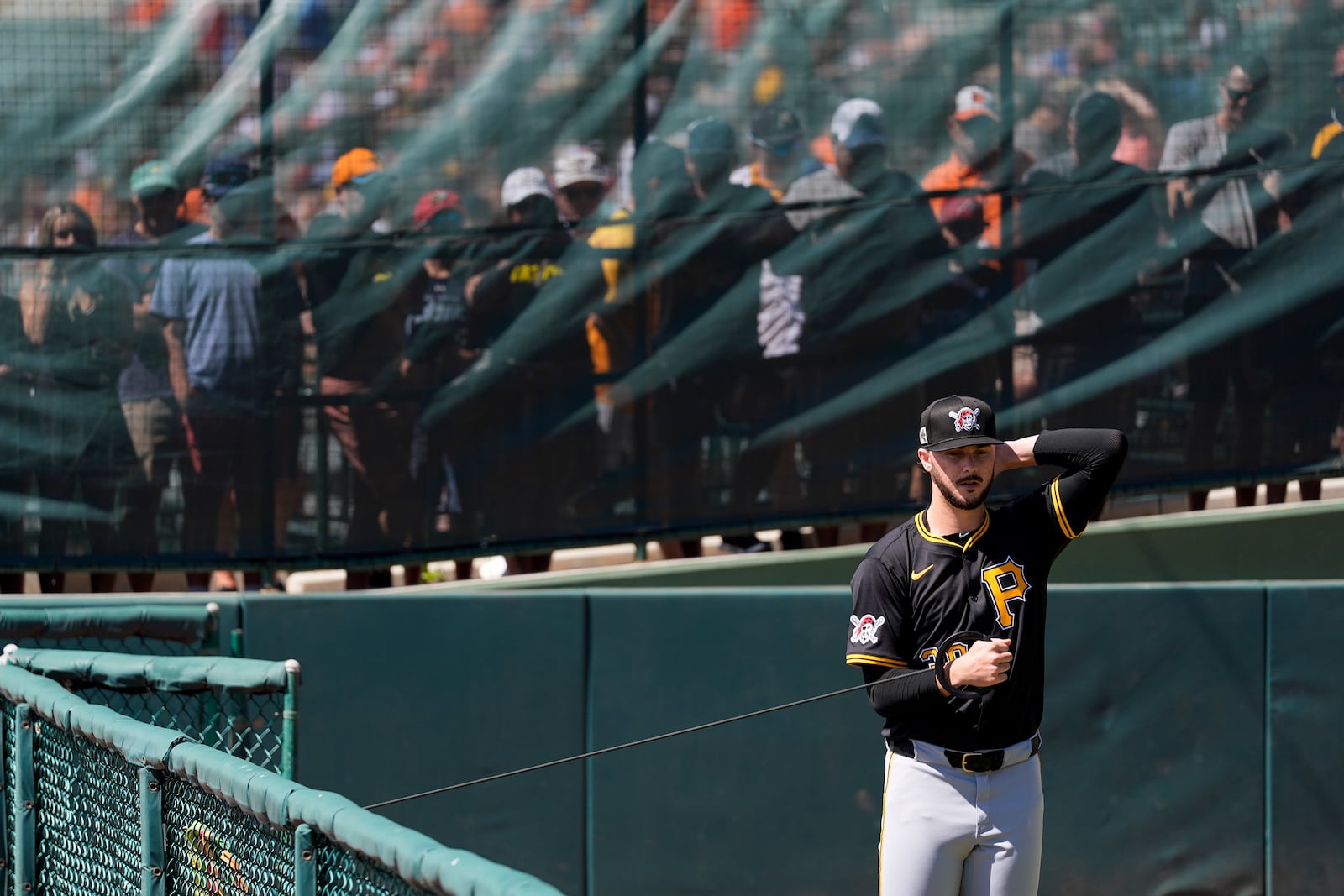 Pittsburgh Pirates starting pitcher Paul Skenes warms up as fans watch behind a fence before a spring training baseball game against the Baltimore Orioles, Saturday, March 1, 2025, in Sarasota, Fla. (AP Photo/Stephanie Scarbrough)