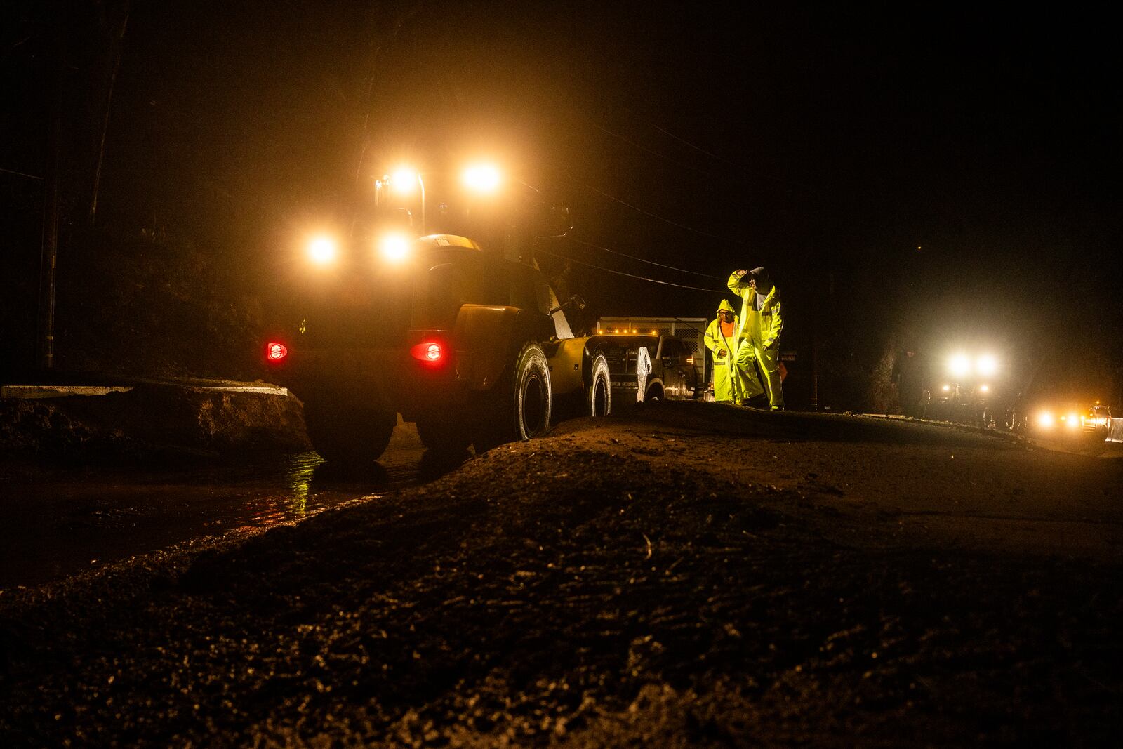 Workers clear mud on a road in the Eaton Fire zone during a storm Thursday, Feb. 13, 2025, in Altadena, Calif. (AP Photo/Etienne Laurent)