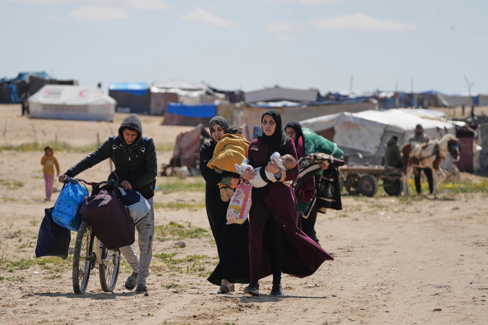 Displaced Palestinians, who flee from Rafah amidst ongoing Israeli military operations following Israel's renewed offensive in the Gaza Strip, arrive in Khan Younis, Gaza, on Sunday, March 23, 2025. (AP Photo/Abdel Kareem Hana)