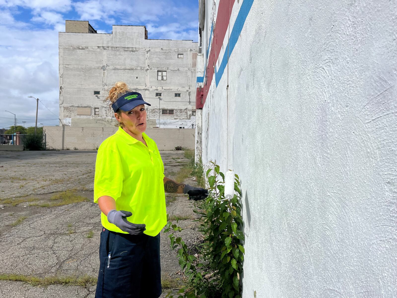 Angel Blanton, special projects ambassador with the Downtown Ambassador program, painted over a tag on the Fidelity building on South Main Street in downtown on Sept. 8, 2023. CORNELIUS FROLIK / STAFF