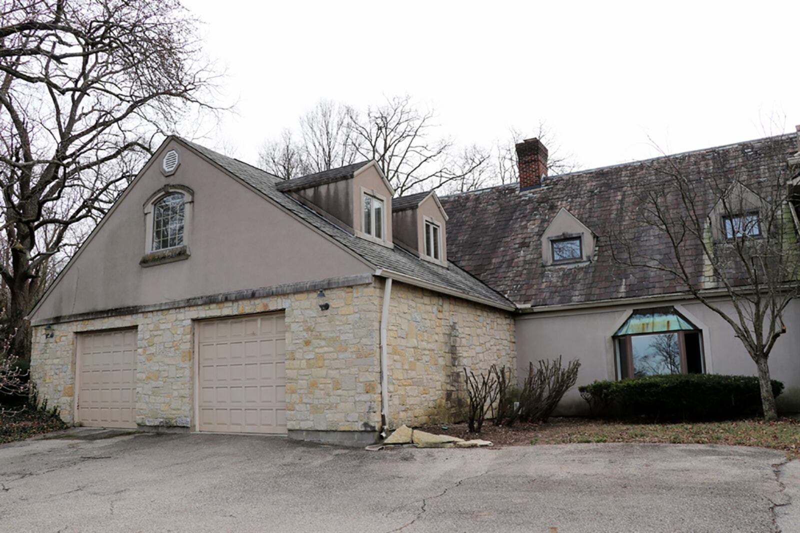 A circular driveway leads to the 2-car garage with oversized bay doors and encircles a stone planter. CONTRIBUTED PHOTO BY KATHY TYLER