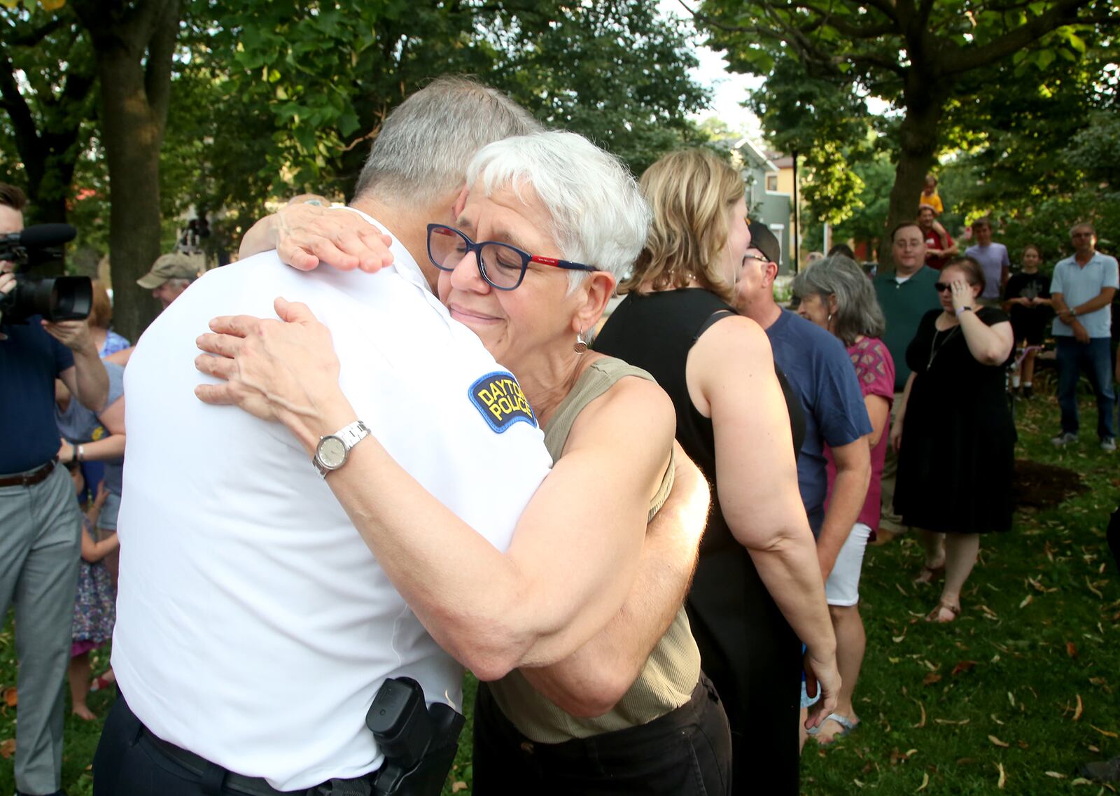 Dayton Police Chief Richard Biehl is hugged by Andrea Raizen, a resident of the Oregon District, during National Night Out events Tuesday in the Oregon District. Dayton officers shot and killed a gunman early Sunday less than one minute after he opened fire in the Dayton entertainment district. The shooter killed nine people before officers shot him to death.