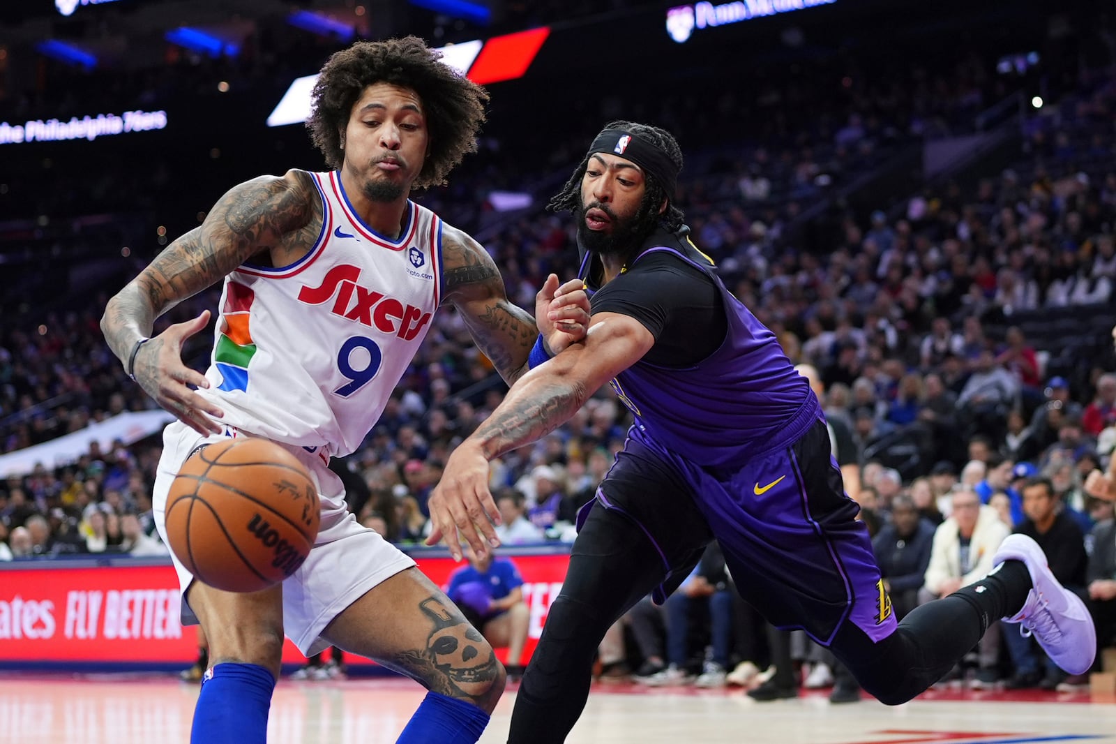 Los Angeles Lakers' Anthony Davis, right, and Philadelphia 76ers' Kelly Oubre Jr. battle for a loose ball during the first half of an NBA basketball game, Tuesday, Jan. 28, 2025, in Philadelphia. (AP Photo/Matt Slocum)