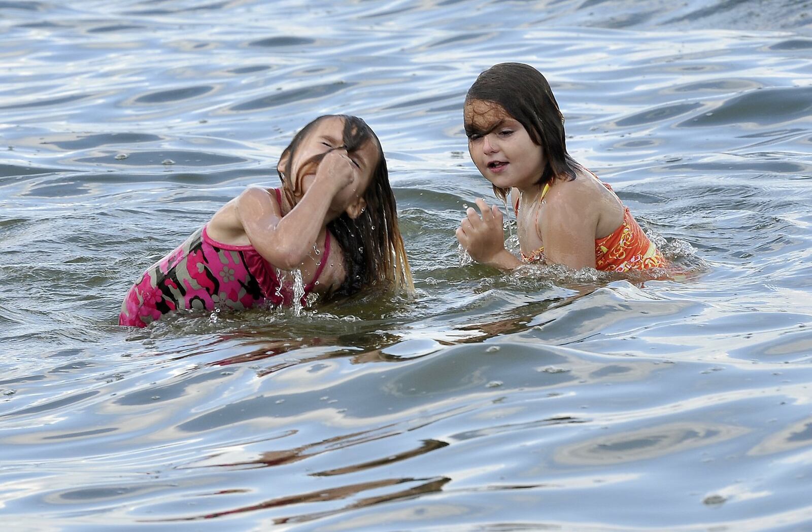 Lana Snow, left, and her sister, Natalia, play in the water at the Buck Creek State Park. Bill Lackey/Staff