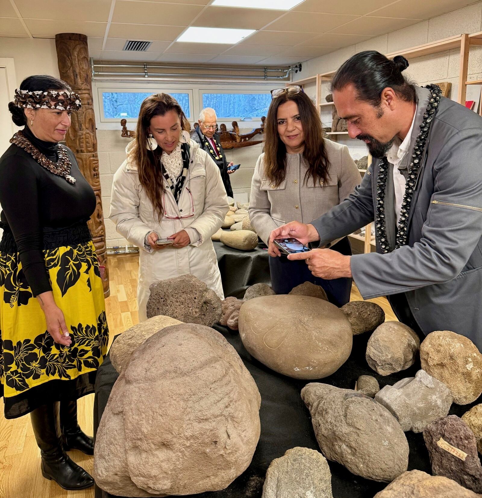 In this photo provided by the Kon-Tiki Museum press service on Wednesday, Nov. 13, 2024, people look at artifacts and human remains taken from Easter Island, also known as Rapa Nui, by a Norwegian explorer in the late 1940s, during the "repatriation" ceremony at the Kon Tiki Museum in Oslo, Norway, Tuesday, Nov. 12, 2024. (Kon-Tiki Museum press service via AP)