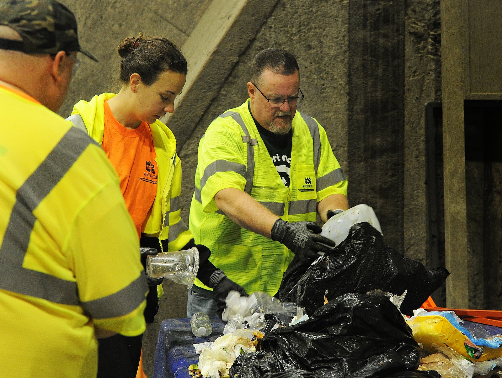 Chris Hoffman, left, Megan O'Leary, and John Woodman sort through bags of trash during a waste audit on Thursday, April 18, 2024. MARSHALL GORBY