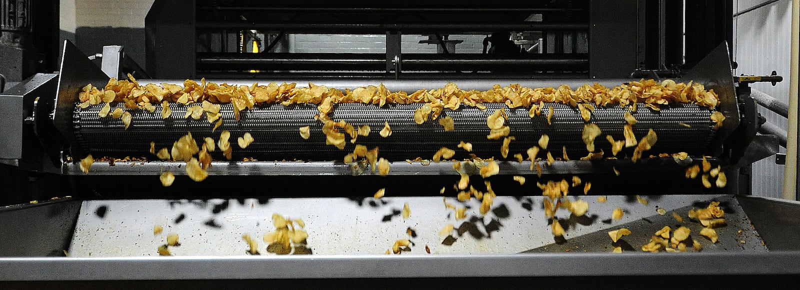 Freshly cooked Mikesell's Potato chips roll along the conveyor belt Thursday Dec. 1, 2022. MARSHALL GORBY\STAFF