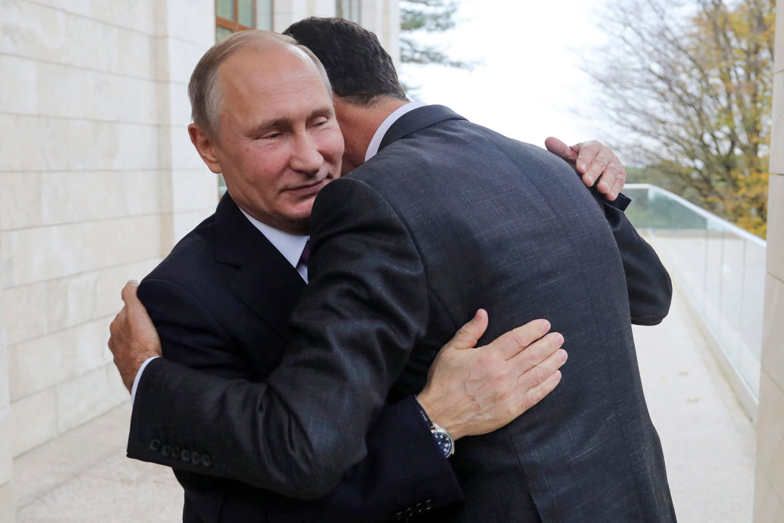 FILE - Russian President Vladimir Putin, left, embraces Syrian President Bashar Assad in the Black Sea resort of Sochi, Russia, on Nov. 21, 2017. (Mikhail Klimentyev, Kremlin Pool Photo via AP, File)