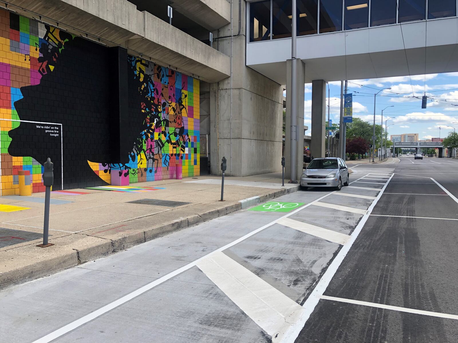 A car blocks the protected bike lane on Jefferson Street in downtown Dayton. CORNELIUS FROLIK / STAFF