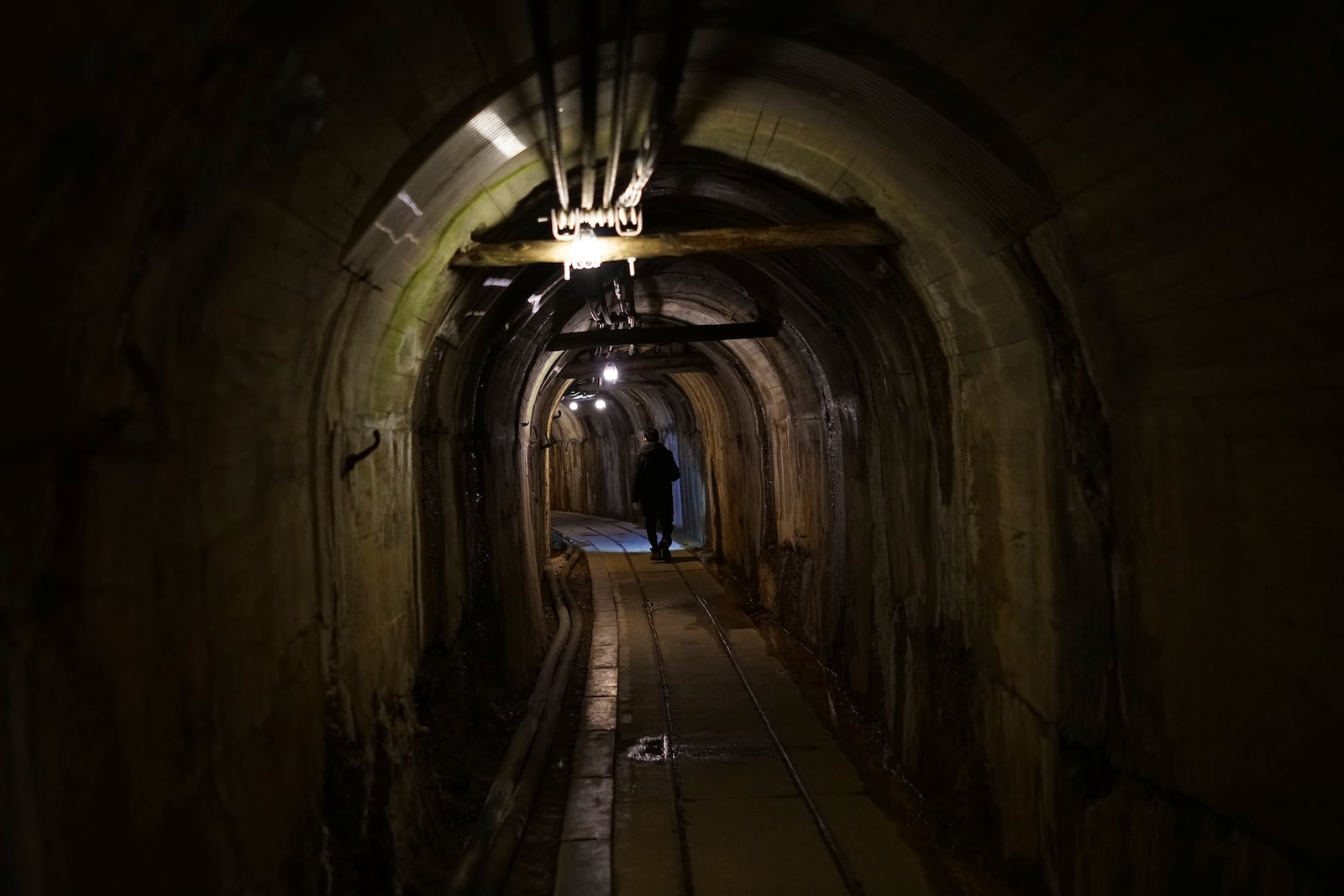 A staff walks through a tunnel at Sado Kinzan Gold Mine historic site in Sado, Niigata prefecture, Japan, Sunday, Nov. 24, 2024. (AP Photo/Eugene Hoshiko)