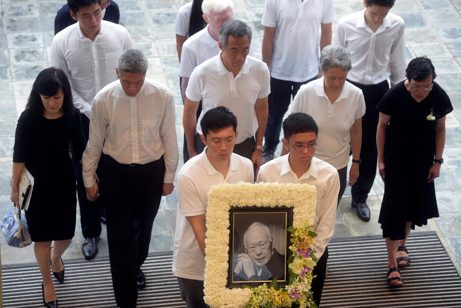 FILE - Family members, second row left to right, Lee Suet Fern, son, (Lee Hsien Yang's wife), Lee Hsien Yang, Lee Hsien Loong, son and current prime minister, Ho Ching (Lee Hsien Loong's wife) and Lee Wei Ling, daughter, of the late Lee Kuan Yew arrive with his portrait at the start of the state funeral at the University Cultural Center in Singapore, Sunday, March 29, 2015. (AP Photo/Joseph Nair, File)