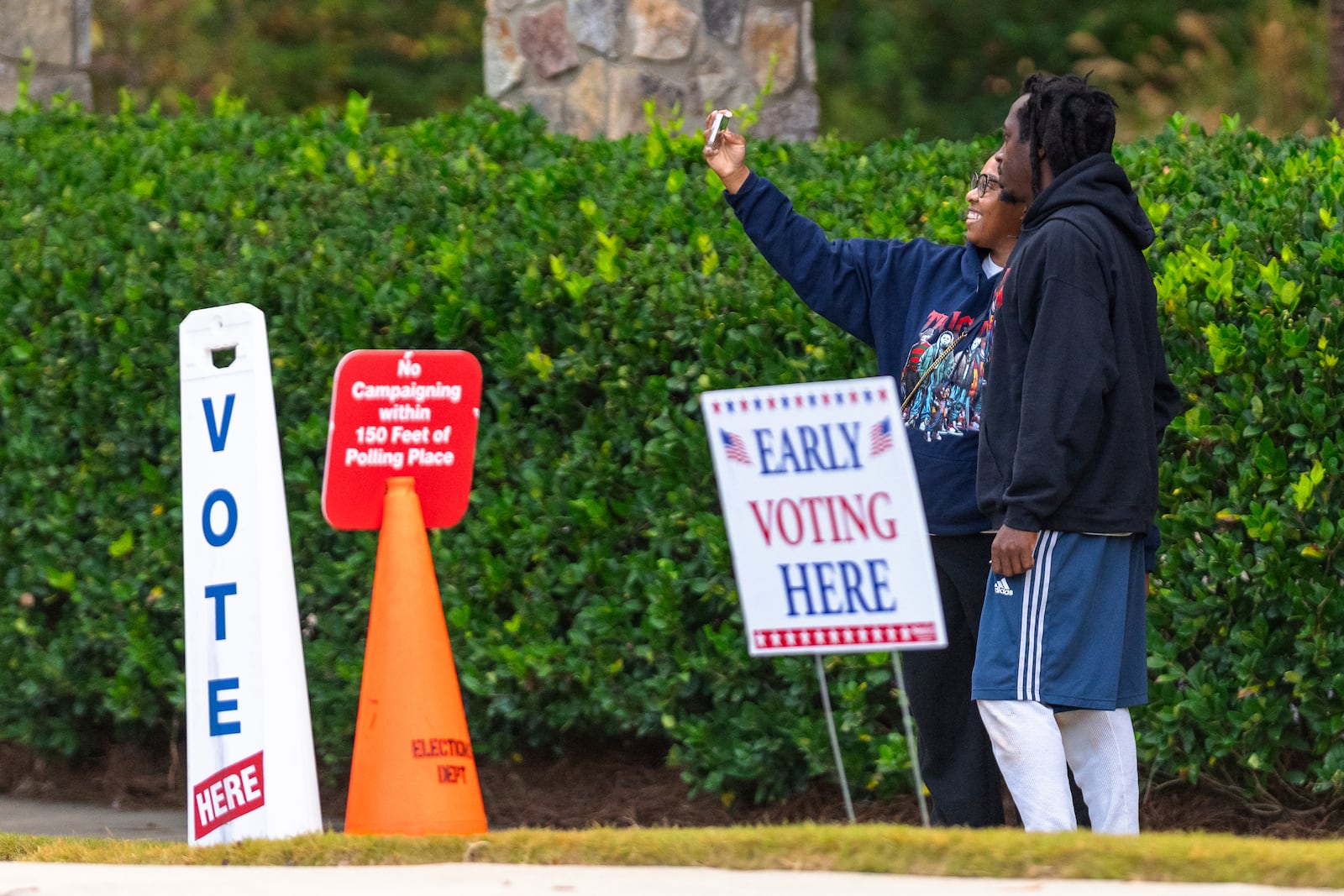 Two voters take a selfie after exiting the polling station, Thursday, Oct. 31, 2024, in Stockbridge, Ga. (AP Photo/Jason Allen)