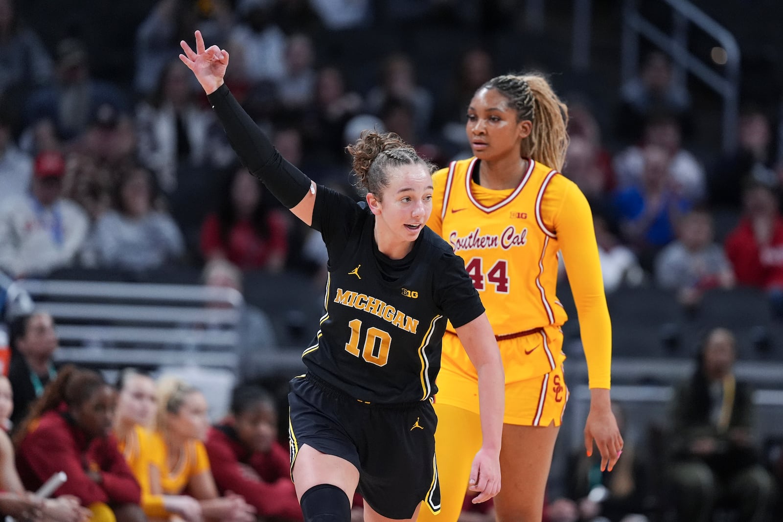 Michigan guard Jordan Hobbs (10) celebrates a three-point basket as Southern California forward Kiki Iriafen (44) looks on during the first half of an NCAA college basketball game in the semifinals of the Big Ten Conference tournament in Indianapolis, Saturday, March 8, 2025. (AP Photo/Michael Conroy)