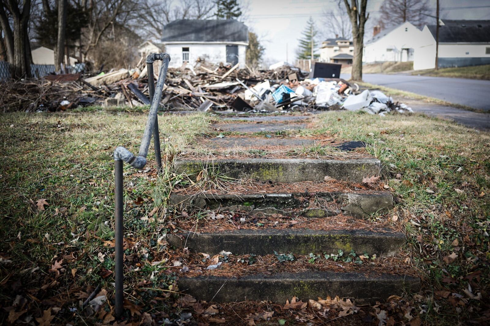 This home on Lorenz Ave. in Dayton burned down last year. The structure was knocked down but the debris was not removed, which has attracted illegal dumping. JIM NOELKER/STAFF