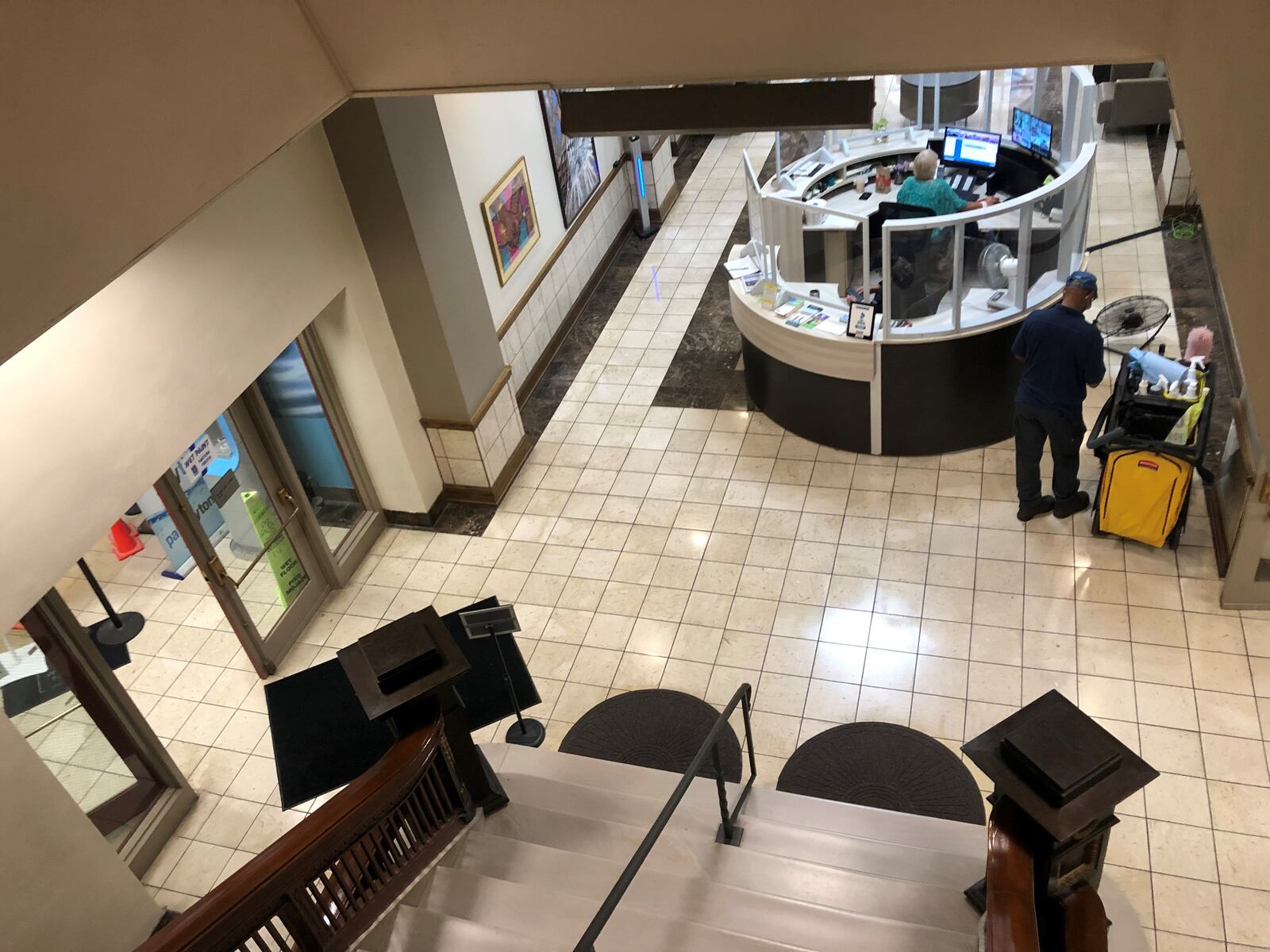 A sanitation worker cleans the front desk area at Dayton City Hall. CORNELIUS FROLIK / STAFF