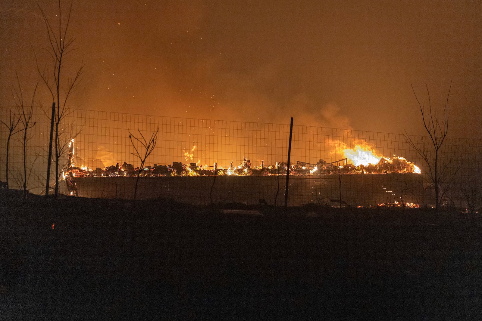 A wildfire burns a home down on Friday, March 14, 2025, south of Langston, Okla. (AP Photo/Alonzo Adams)