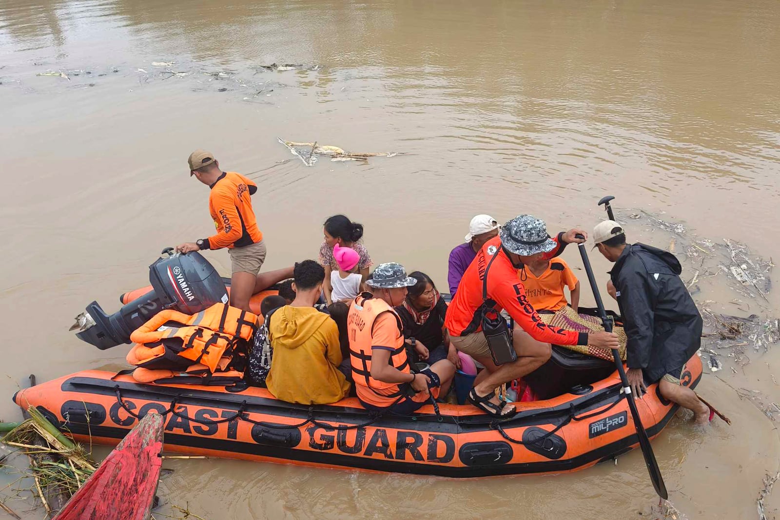 Residents are ferried on a rubber boat after being rescued from their roofs where they stayed to avoid high floods caused by Tropical Storm Trami hit Libon town, Albay province, Philippines on Wednesday Oct. 23, 2024. (Michelle Ricasio via AP)