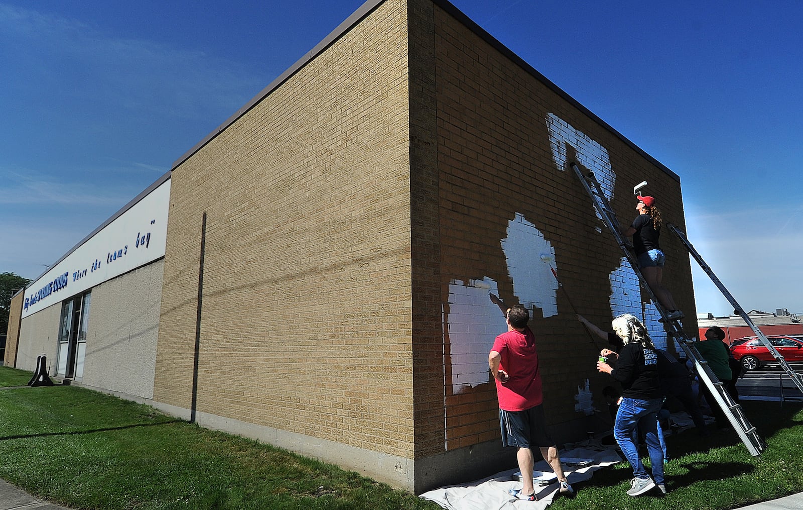 Volunteers started Friday, May 31, 2024 on a suicide prevention mural on the Tuffy Brooks Sporting Goods building, located at 101 S. Keowee St. in Dayton as part of an initiative from the Montgomery County Prevention Coalition to spread messages of hope. The mural will also feature a QR code with a link to mental health resources. MARSHALL GORBY\STAFF