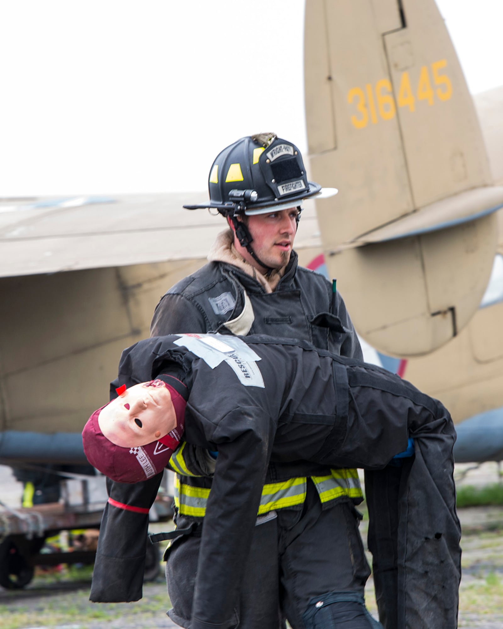 A firefighter from the 788th Civil Engineer Squadron carries a dummy "victim" to safety on May 5 during a mass-casualty exercise at Wright-Patterson Air Force Base. T U.S. AIR FORCE PHOTO/JAIMA FOGG