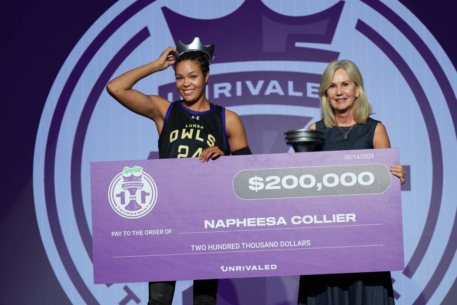 Napheesa Collier, left, holds a mock check for $200,000 along with Micky Lawler, commissioner of Unrivaled Basketball after Collier defeated Aaliyah Edwards in the Unrivaled 1-on-1 basketball final, Friday, Feb. 14, 2025, in Medley, Fla. (AP Photo/Rebecca Blackwell)