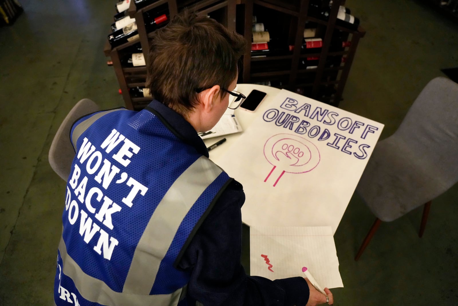 Cole Archer works on a protest sign during a meeting of NC Forward in High Point, N.C., Tuesday, Jan. 14, 2025. The group is traveling to Washington to take part in the People's March on Jan. 18 ahead of the inauguration. (AP Photo/Chuck Burton)