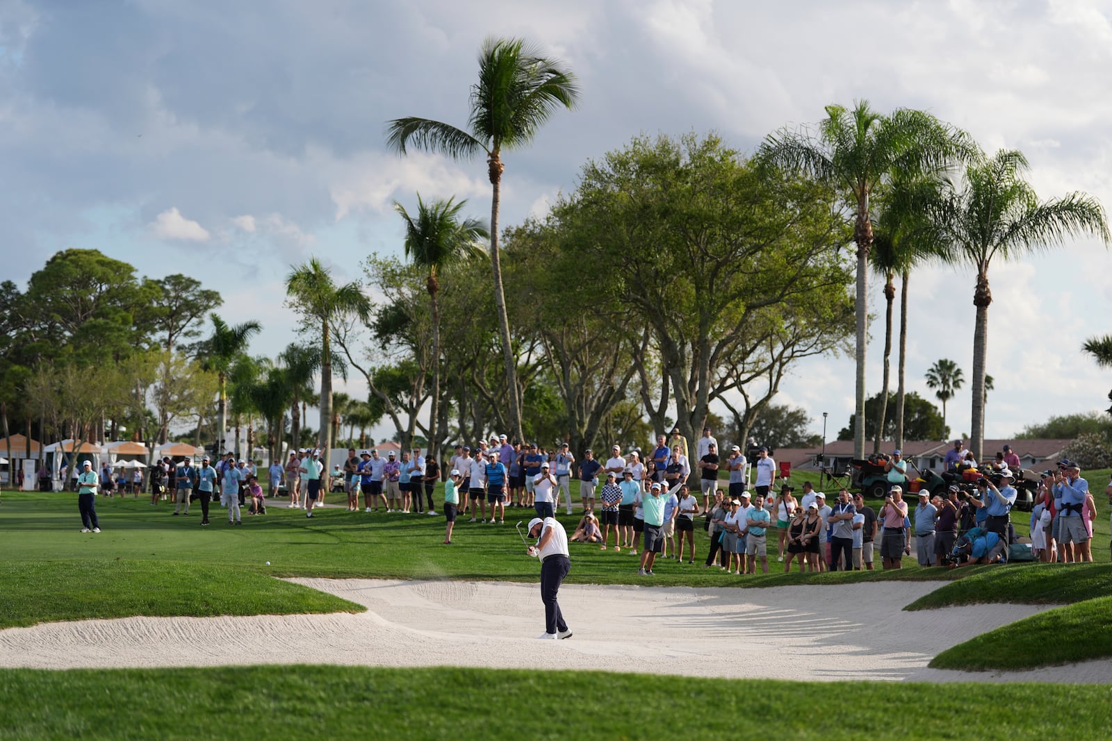 Fans watch as Shane Lowry hits out of a fairway bunker on the 16th hole during the first round of the Cognizant Classic golf tournament, Thursday, Feb. 27, 2025, in Palm Beach Gardens, Fla. (AP Photo/Rebecca Blackwell)