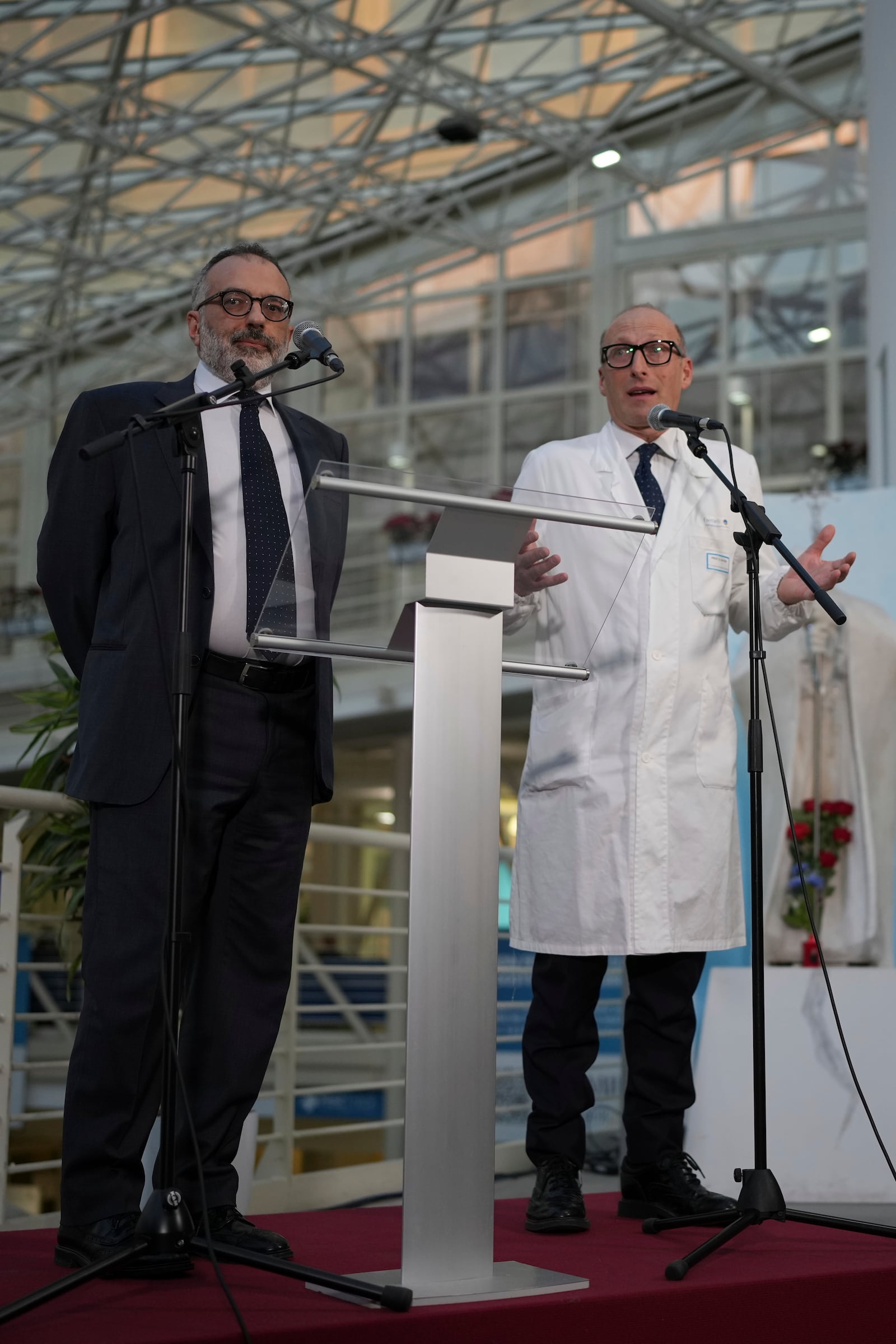 Surgeon Sergio Alfieri, right, and head physician of the Vatican's health and hygiene office, Luigi Carbone speak to journalists, Friday, Feb. 21, 2025, in the entrance hall of Rome's Agostino Gemelli Polyclinic where Pope Francis is being treated for pneumonia. (AP Photo/Alessandra Tarantino)