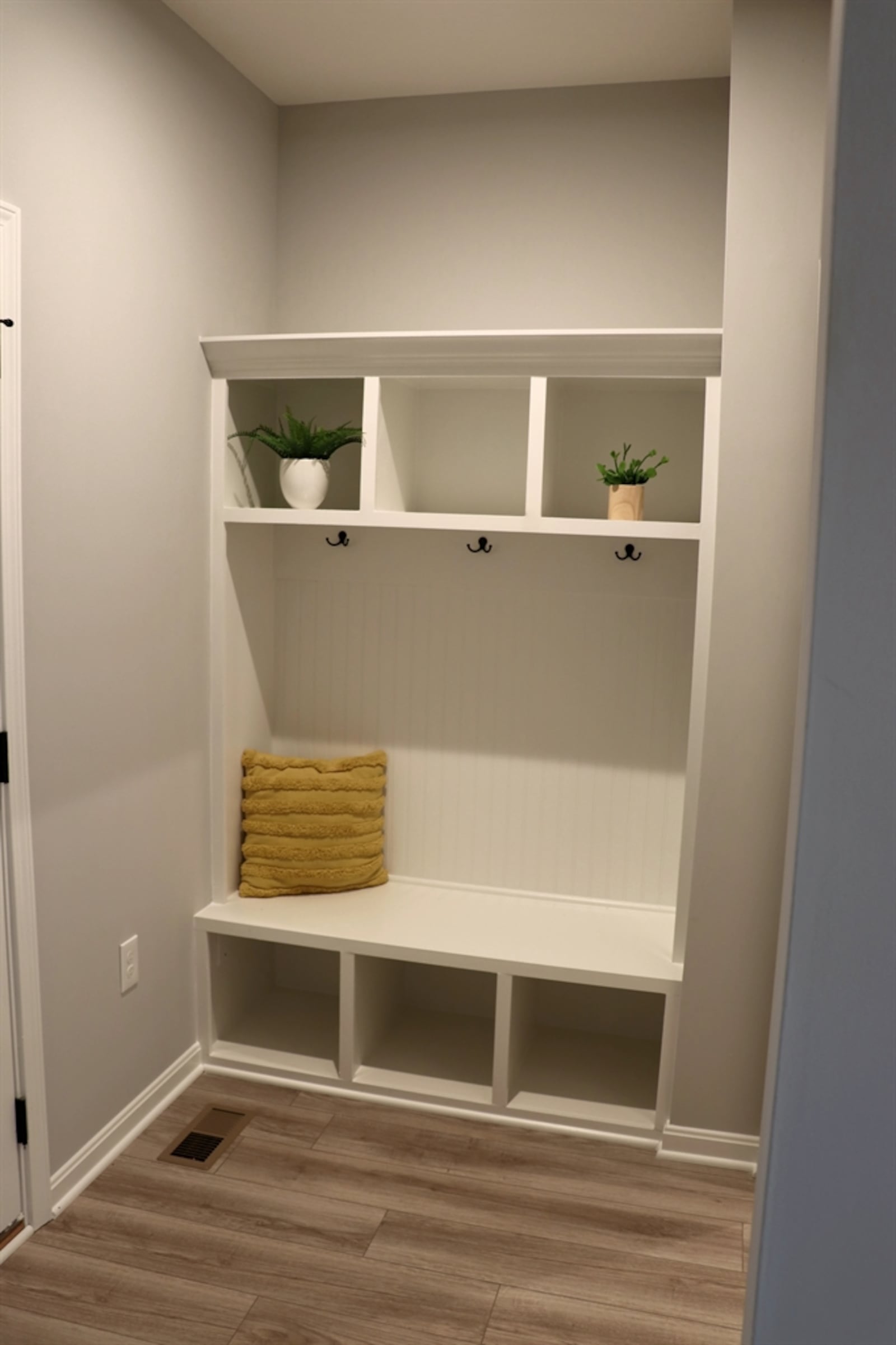 A mudroom has a built-in locker bench and provides access to the garage and laundry room.