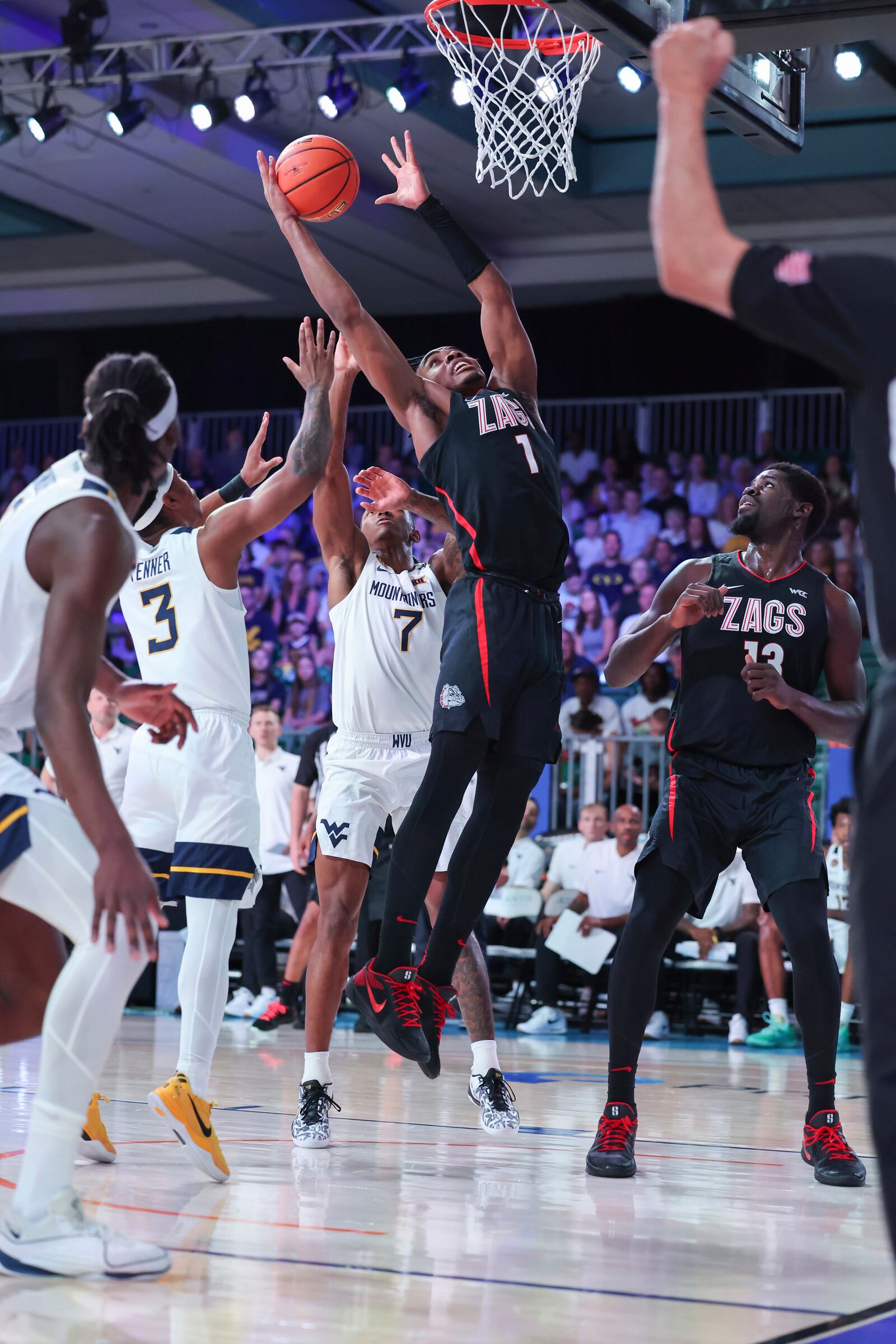 In this handout provided by Bahamas Visual Services, Gonzaga guard Michael Ajayi (1) reaches for the ball as West Virginia defenders and teammate Graham Ike (13) look on during an NCAA college basketball game at the Battle 4 Atlantis tournament in Paradise Island, Bahamas Wednesday, Nov. 27, 2024. (Tim Aylen/Bahamas Visual Services via AP)