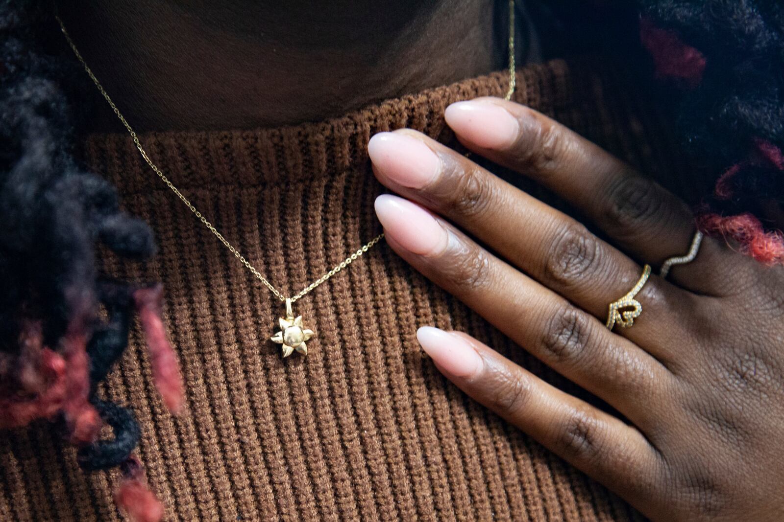 Doneysha Smith wears a sun-shaped necklace containing the ashes of her son Lux Siloam at her home in Sherwood, Arkansas, Tuesday, Feb. 11, 2025. After being stillborn at 18 weeks, Lux's body was stolen and sold to traffickers in two states, prompting an FBI investigation. A proposed law, known as Lux's Law, would prohibit the sale of dead bodies that were intended to be cremated or buried and establish penalties in Arkansas. (AP Photo/Katie Adkins)