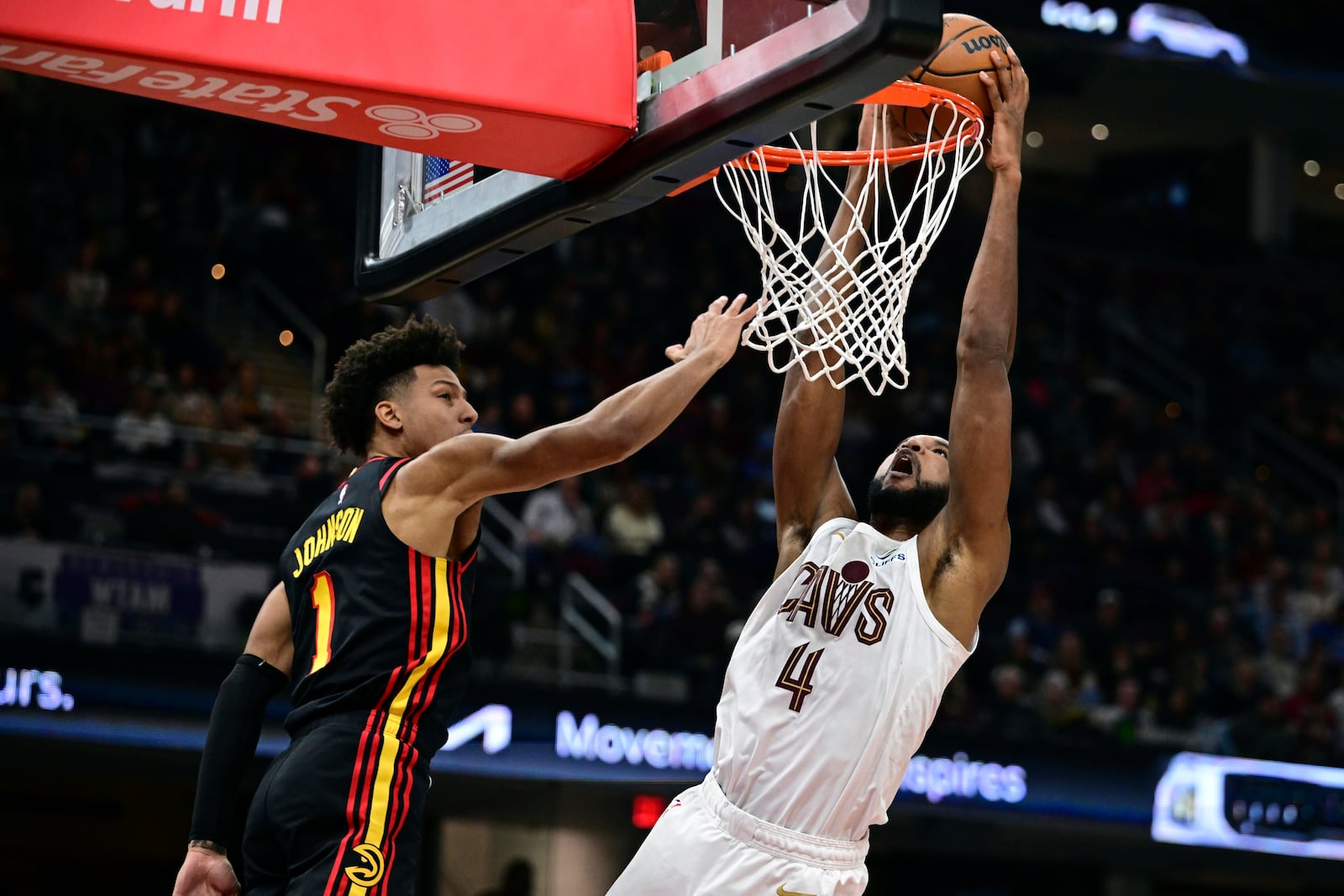 Cleveland Cavaliers forward Evan Mobley dunks against Atlanta Hawks forward Jalen Johnson in the first half of an NBA basketball game, Wednesday, Nov. 23, 2024, in Cleveland. (AP Photo/David Dermer)