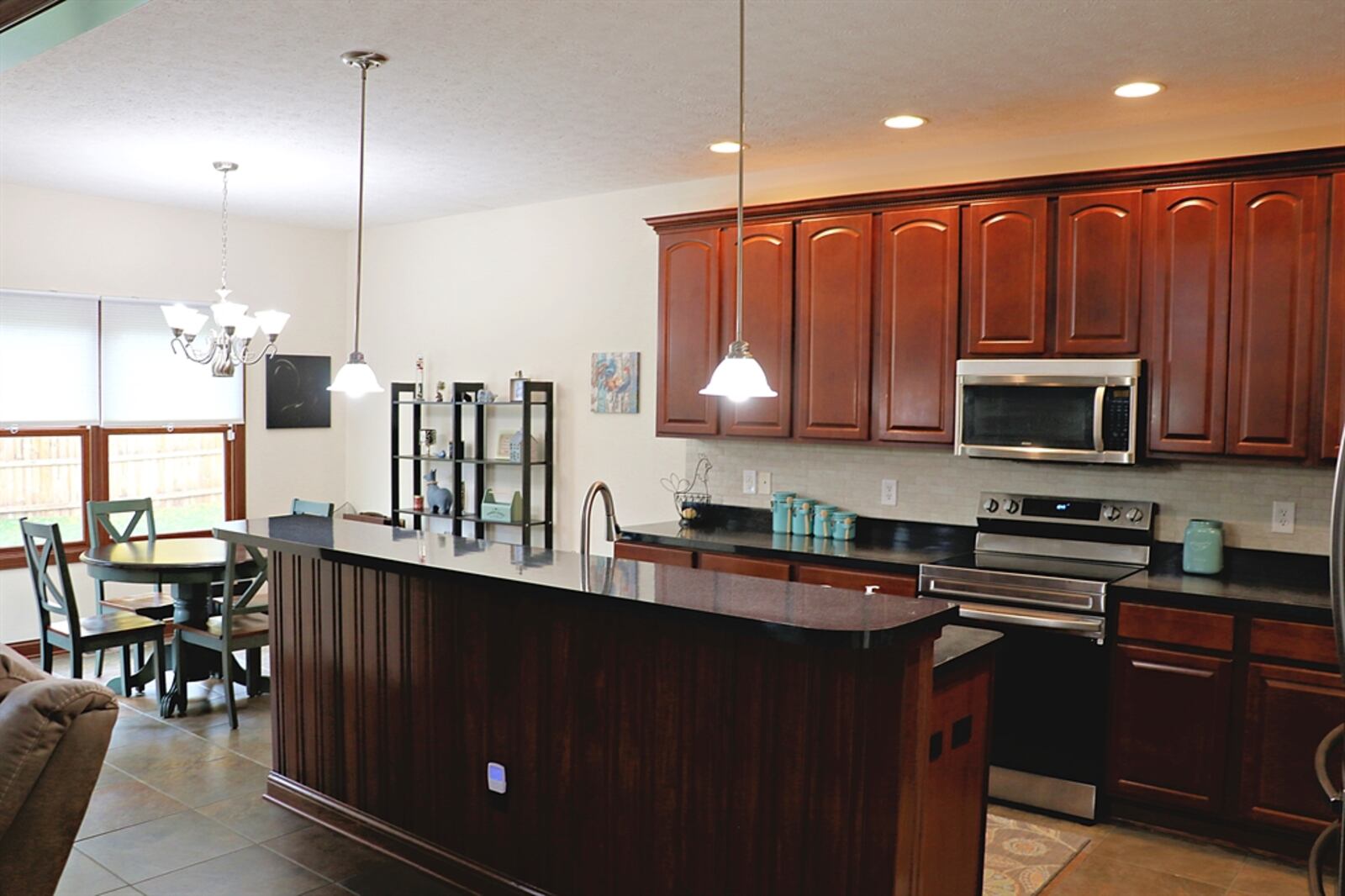 Dark granite counters complement the 42-inch cherry cabinetry of the gourmet kitchen.