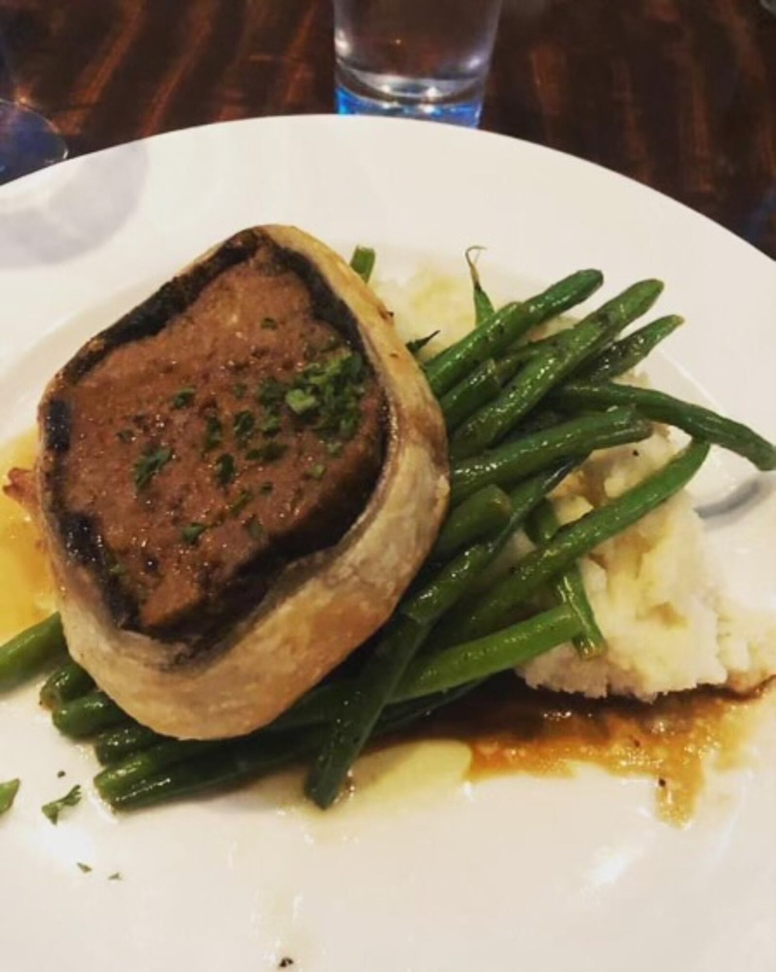 Watermark's Meatloaf Wellington: Mushroom duxelles and puff pastry wrapped around meatloaf with french green beans , garlic mashed potatoes and sherry demi glace