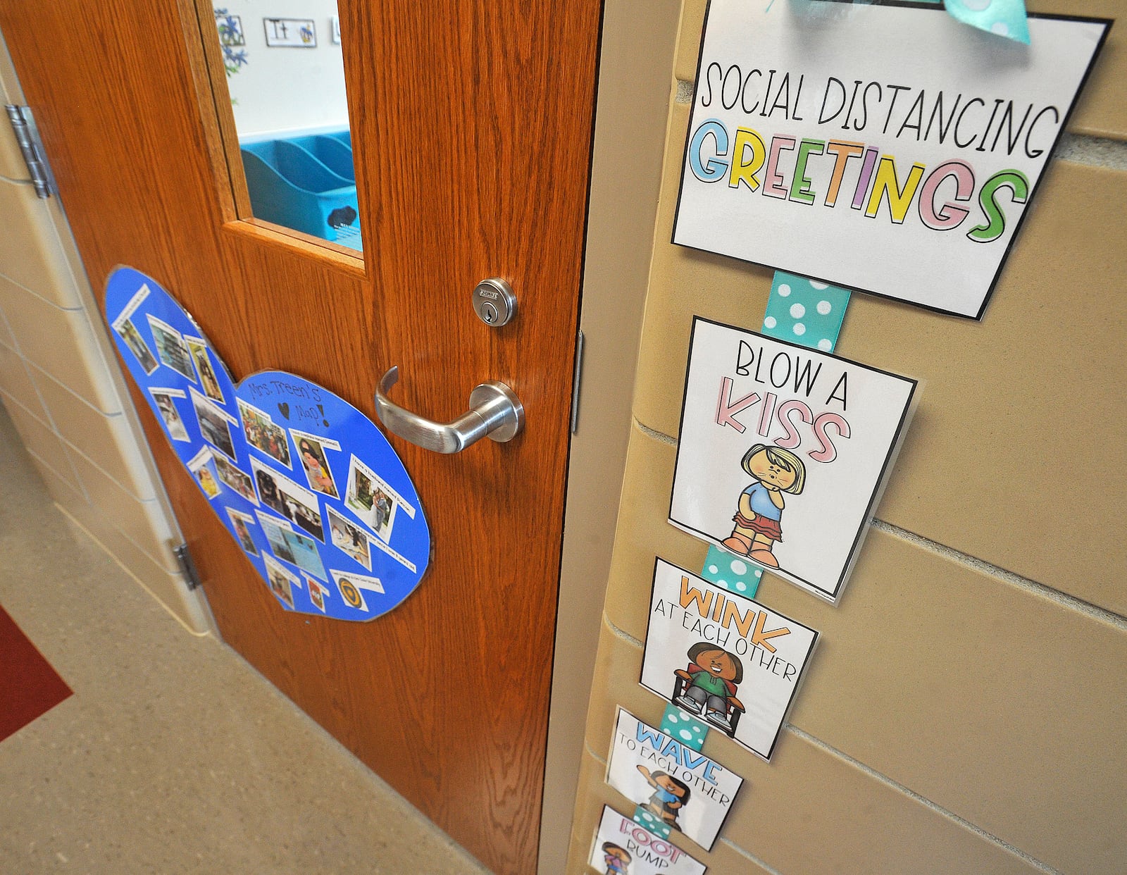 A kindergarden teacher at Orchard Park Elementary, in Kettering, offers different ways to offer social distancing greetings.  MARSHALL GORBY\STAFF