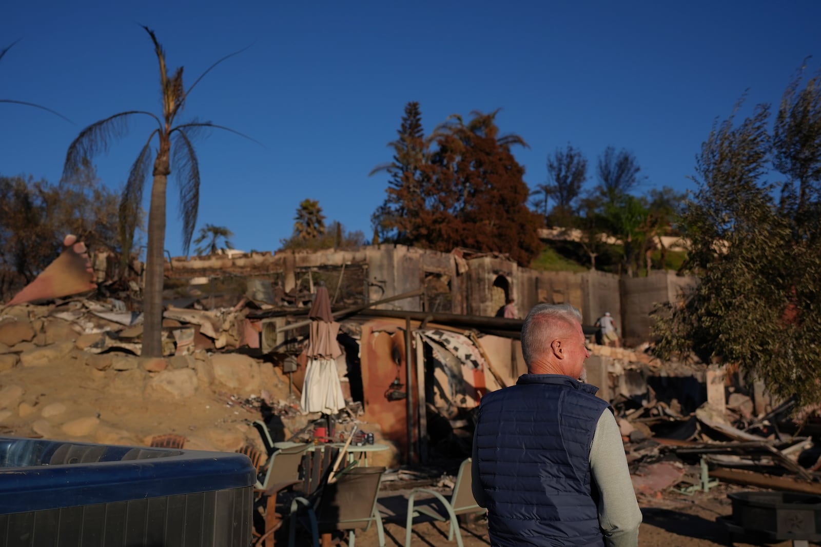 Bill Nardoni, foreground, and family friends search his home destroyed by the Mountain Fire in Camarillo, Calif., Friday, Nov. 8, 2024. (AP Photo/Jae C. Hong)