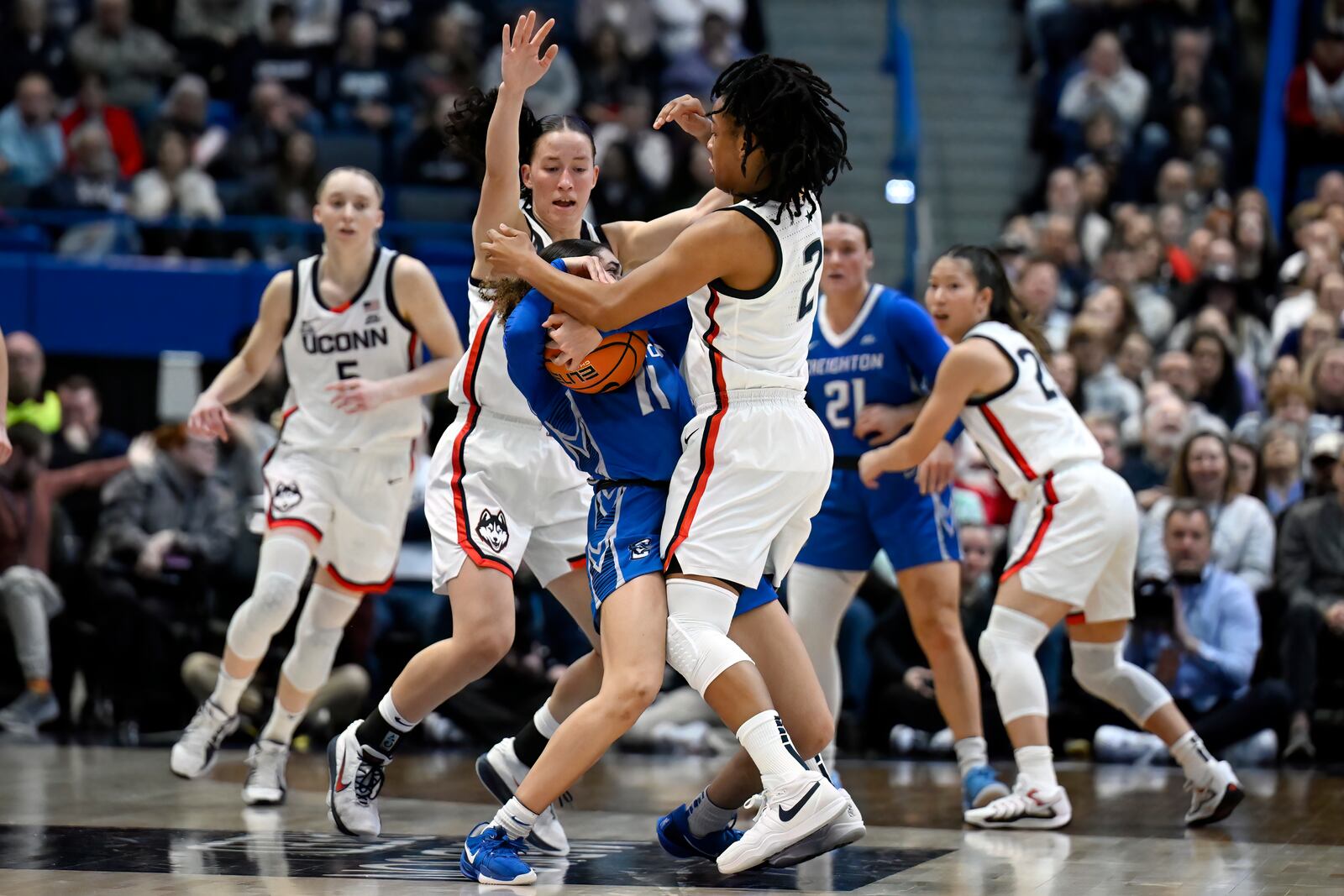 UConn guards Ashlynn Shade, left, and KK Arnold, right, pressure Creighton guard Kiani Lockett, center, in the first half of an NCAA college basketball game, Thursday, Feb. 27, 2025, in Hartford, Conn. (AP Photo/Jessica Hill)