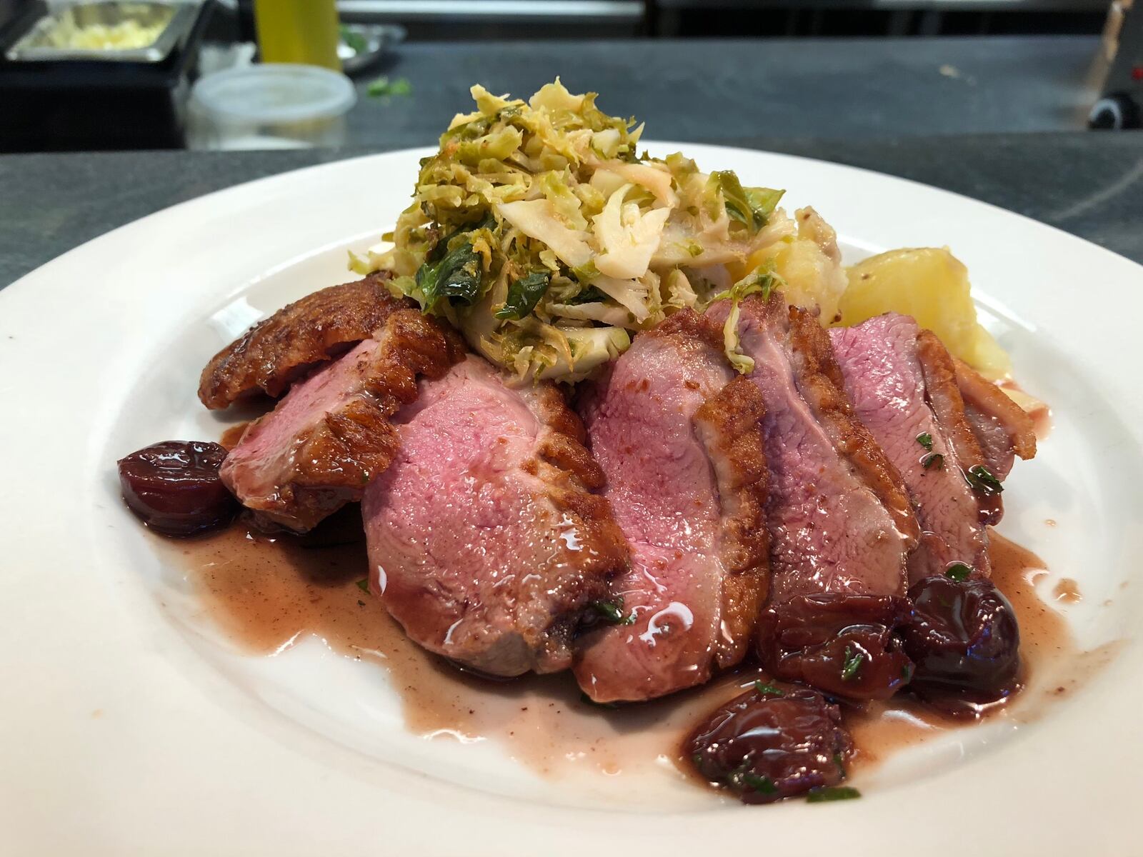 Corner Kitchen's pan-seared duck breast served with a cherry compote, accompanied by a warm potato and leek salad, and braised brussel sprouts. CONTRIBUTED